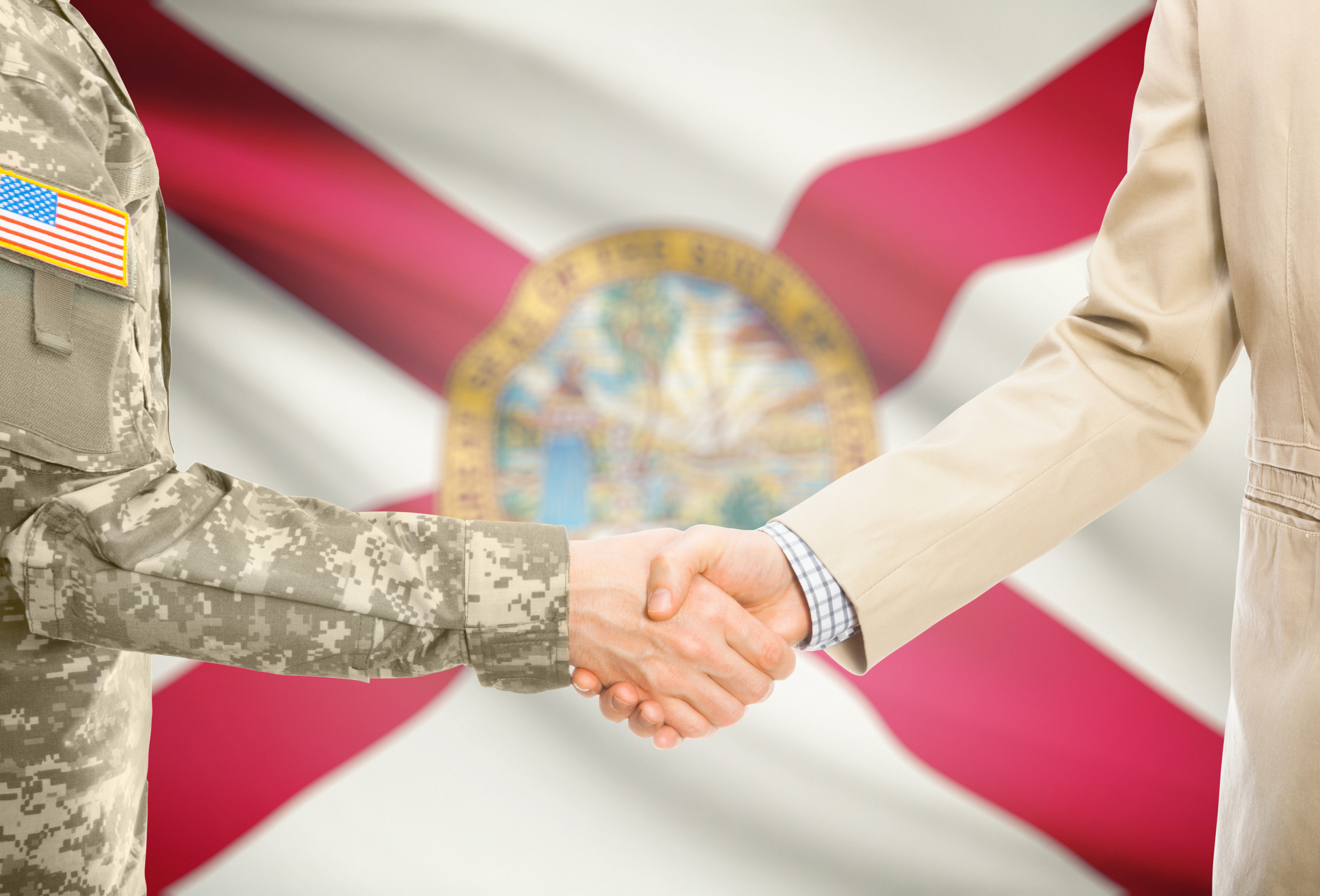 USA military man in uniform and civil man in suit shaking hands with USA state flag on background - Florida