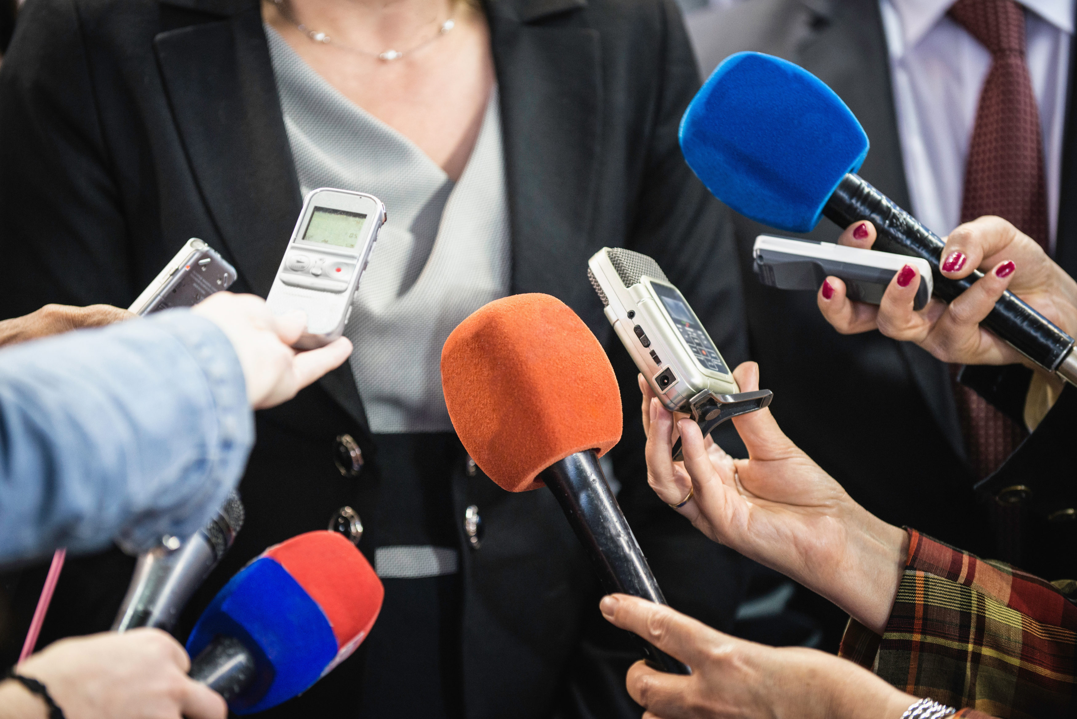 Female politician surrounded with journalists