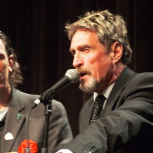 John McAfee talks while Darryl Perry listens.