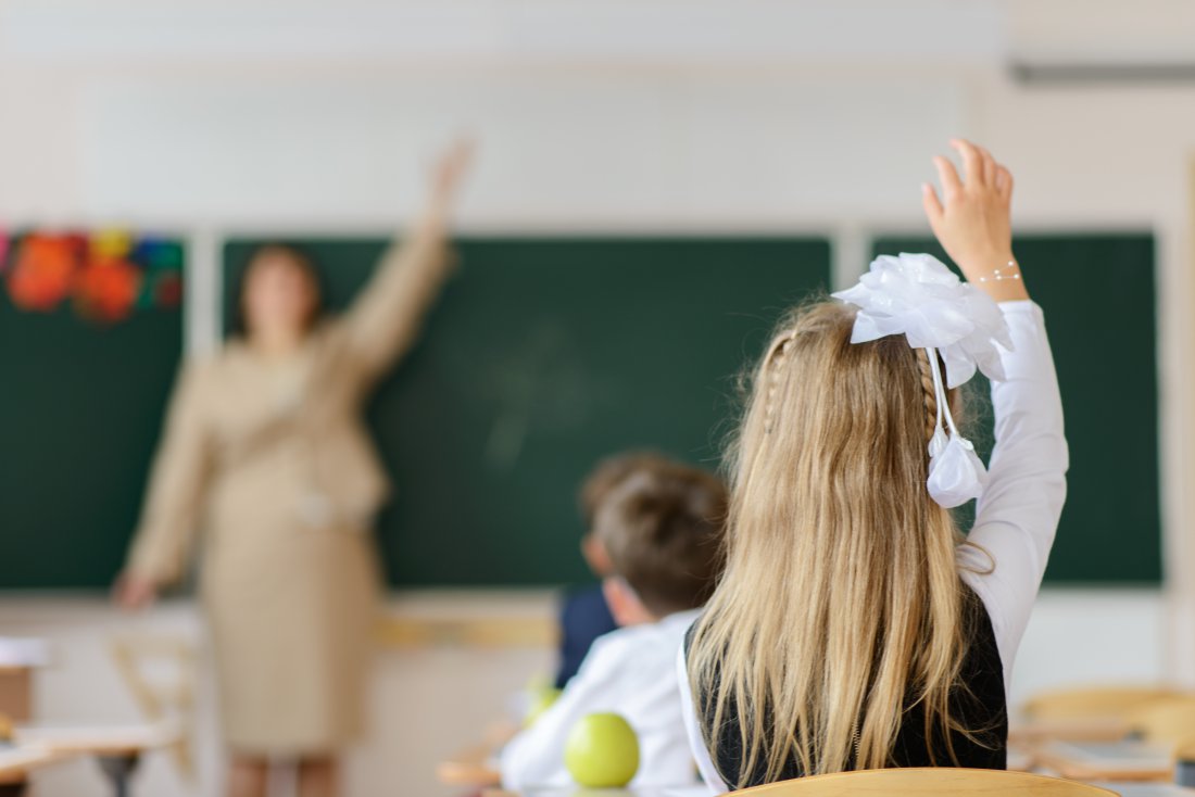 Schoolchild raising hand to answer