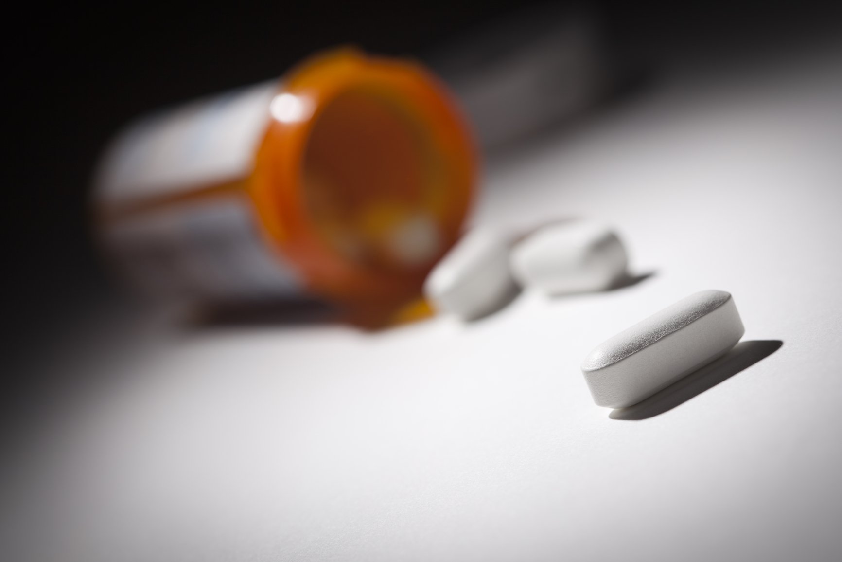 Medicine Bottle and Pills Under Spot Light Abstract.