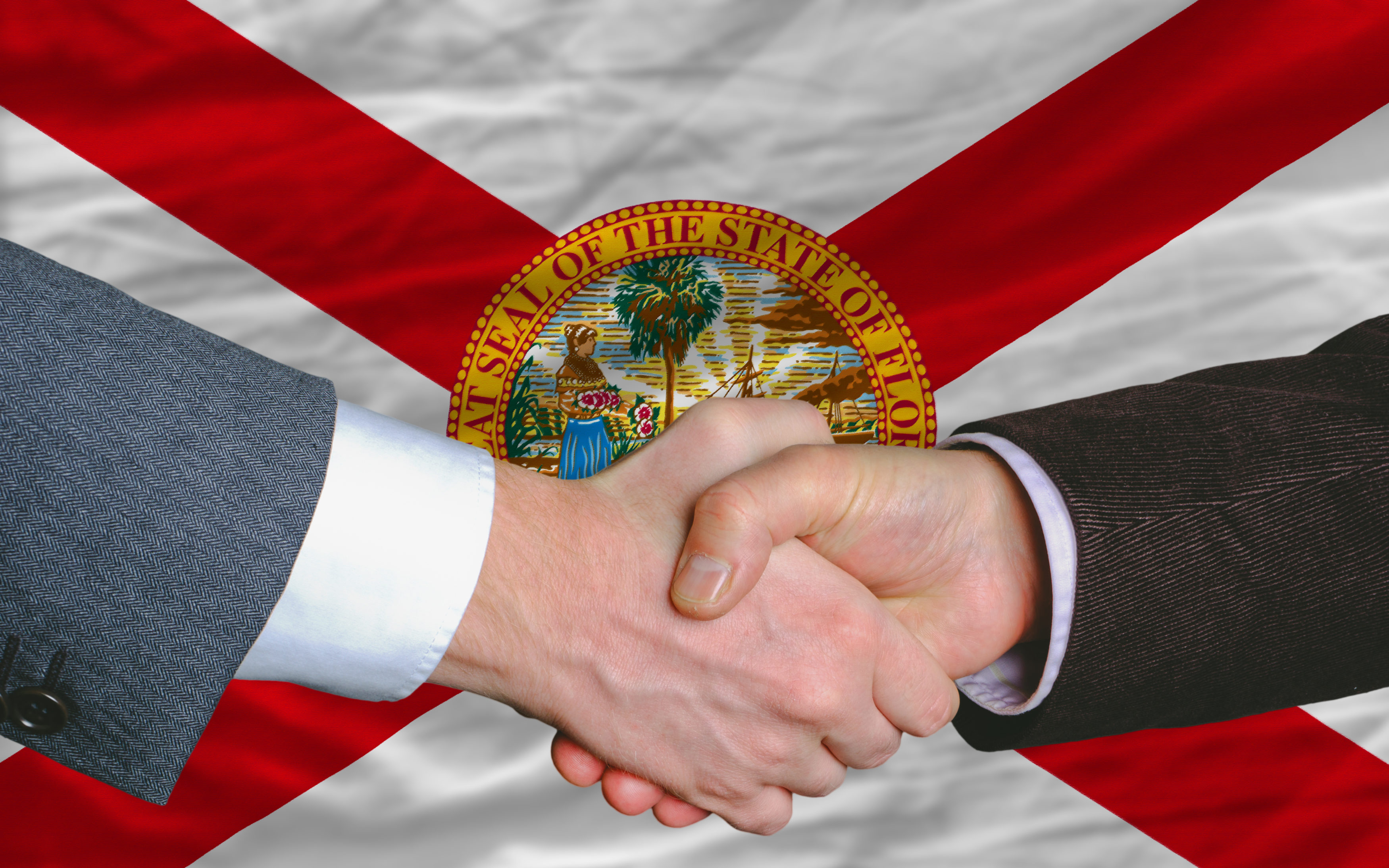 in front of american state flag of florida two businessmen hands