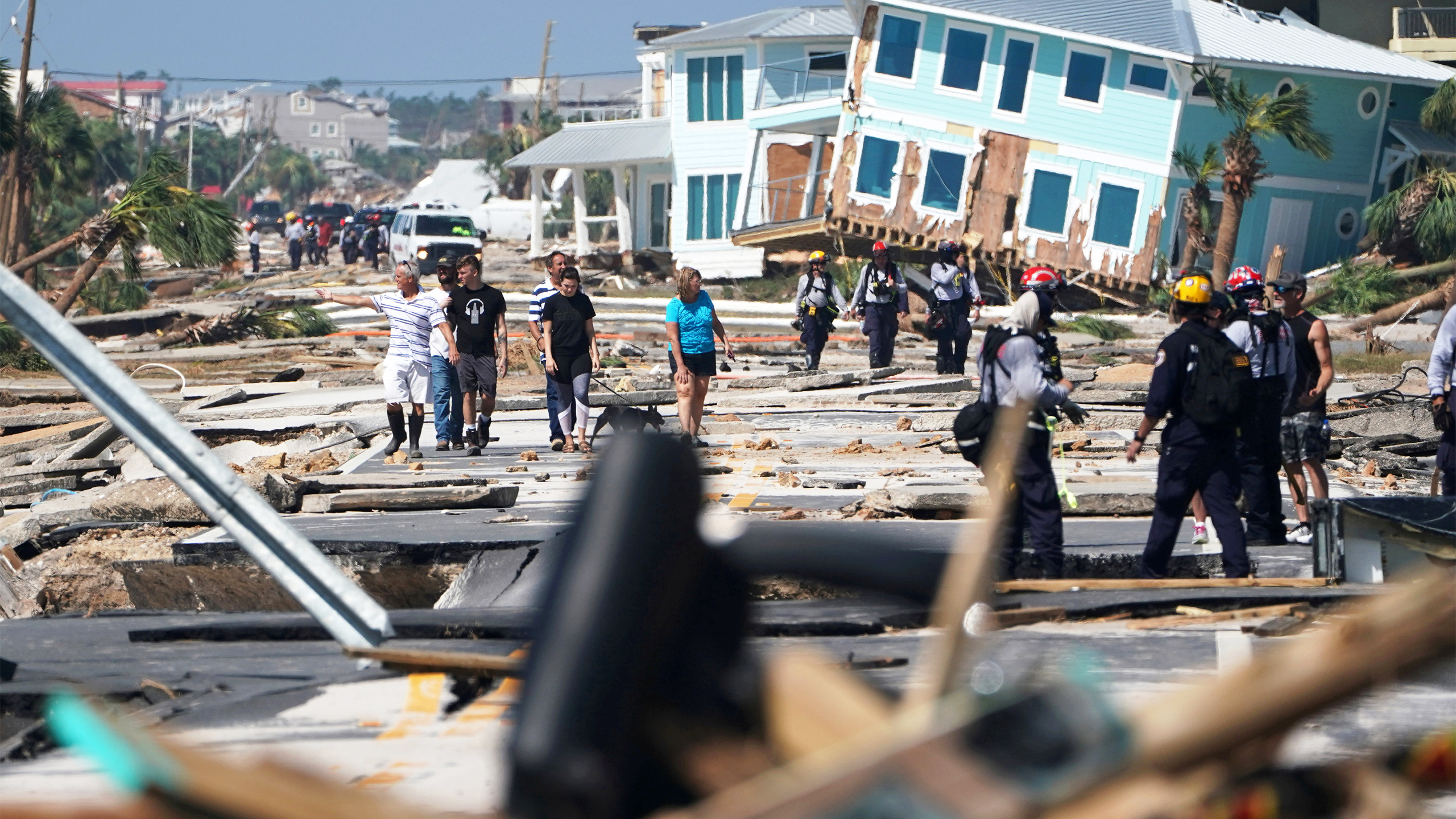 First responders and residents walk along a main street following Hurricane Michael in Mexico Beach