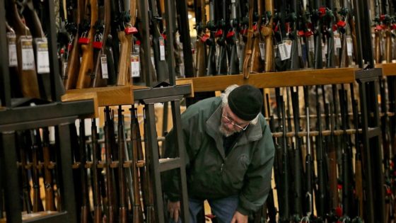 FILE - In this Nov. 29, 2019, file photo, a man looks at the shotgun section of Cabela's while shopping on Black Friday in Hazelwood, Mo. The number of background checks conducted by federal authorities is on pace to break a record by the end of this year. (Christian Gooden/St. Louis Post-Dispatch via AP)