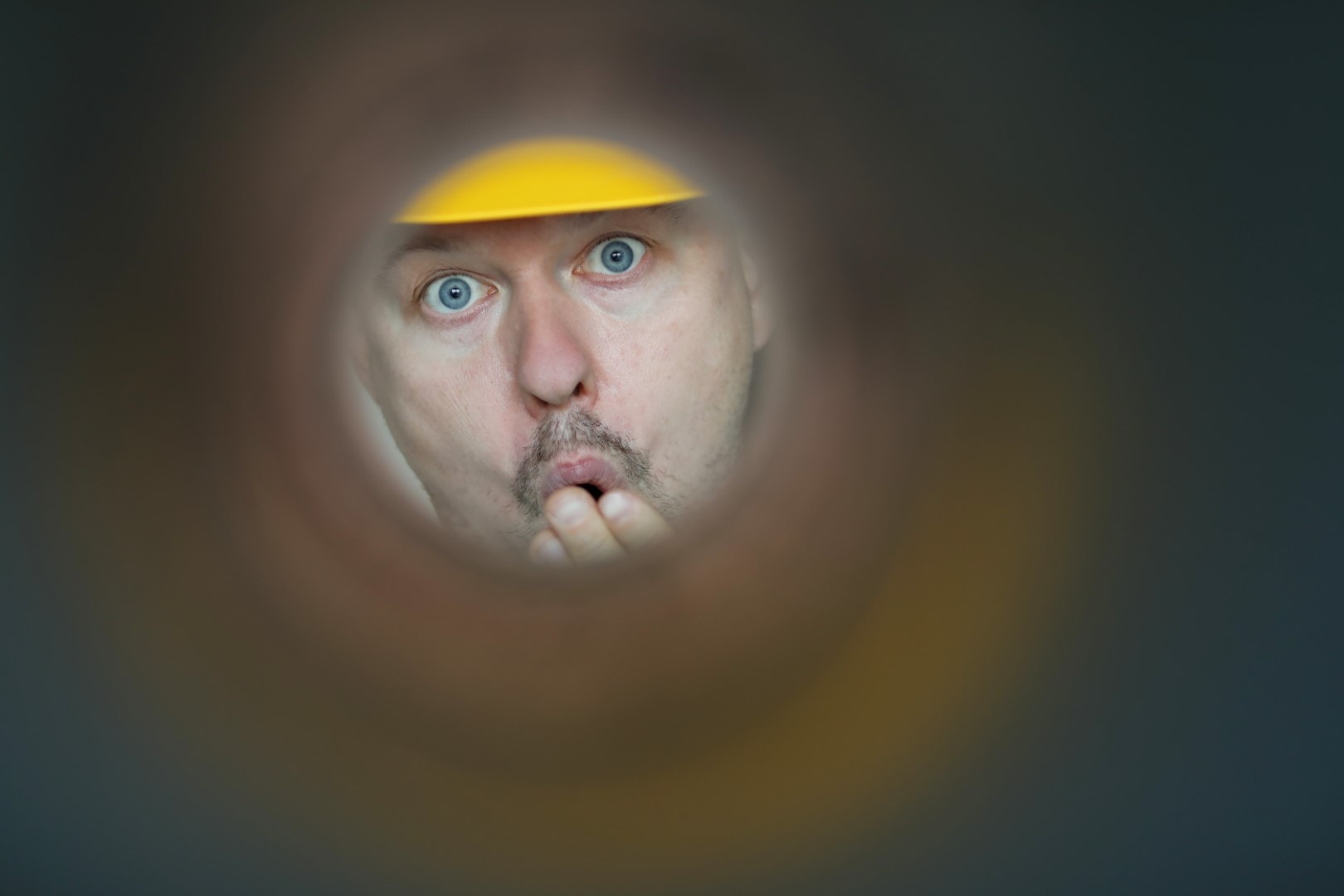 Male plumber looks into contaminated pipe