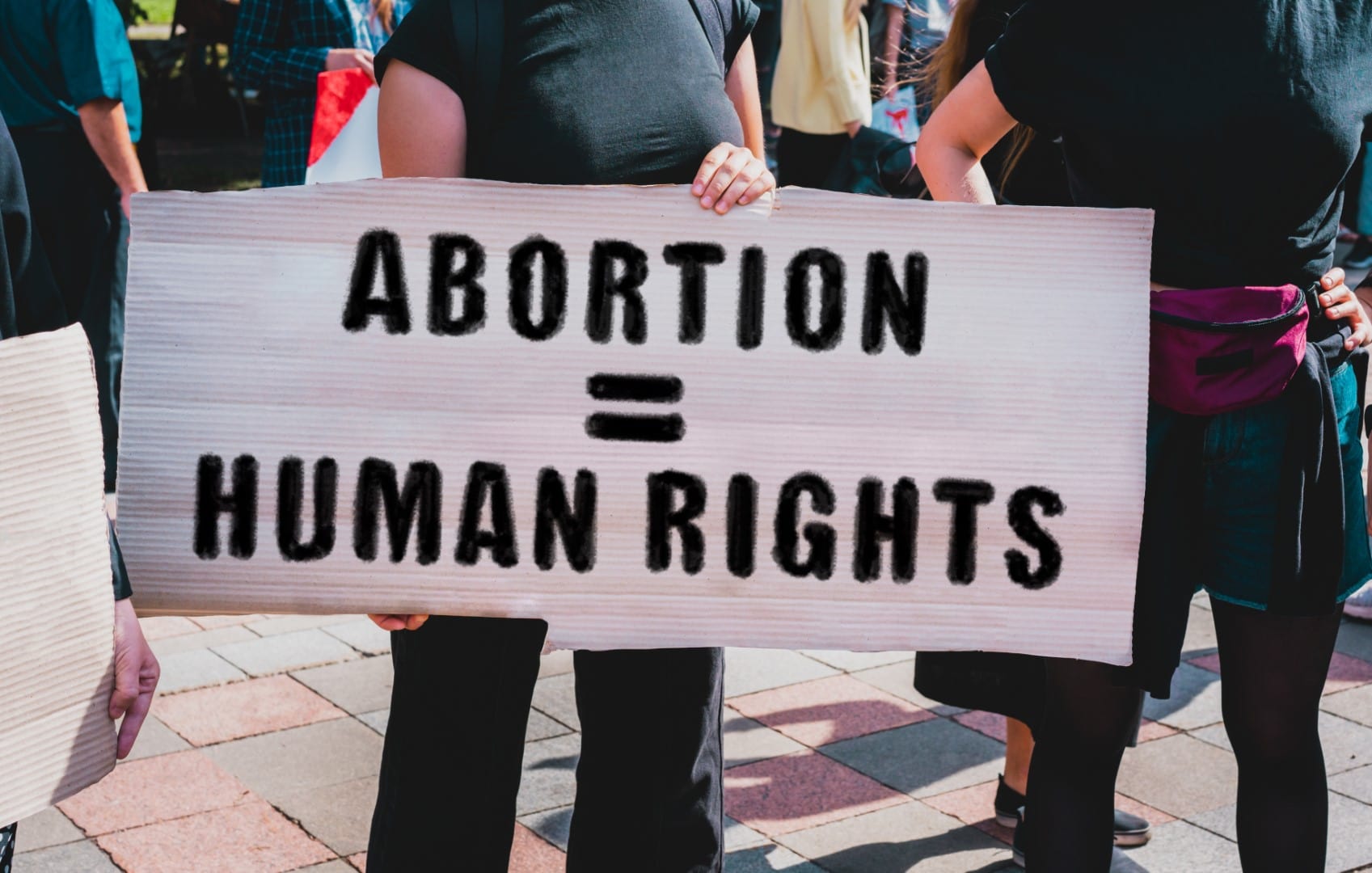 The phrase " Abortion = human rights " drawn on a carton banner in hand. Movement against the prohibition on abortion. A girl holds a cardboard with an inscription. Women's rights protest. Rally