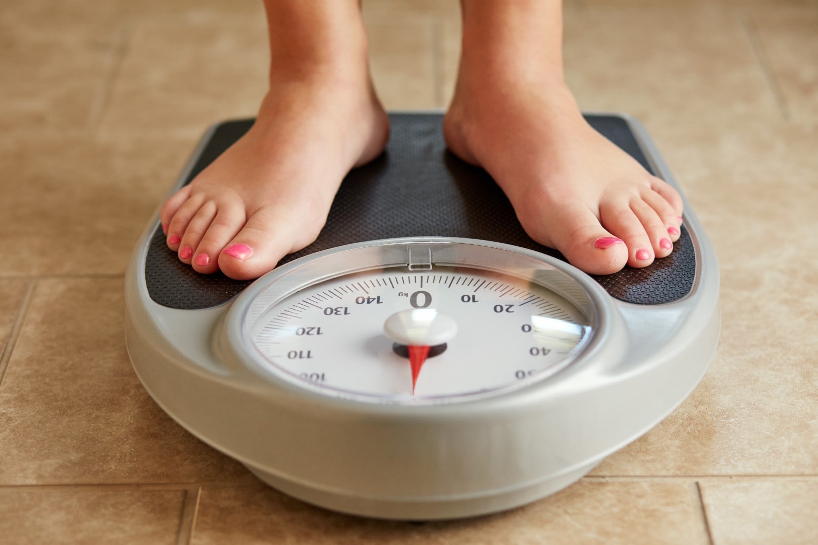 Female feet on a bathroom scale