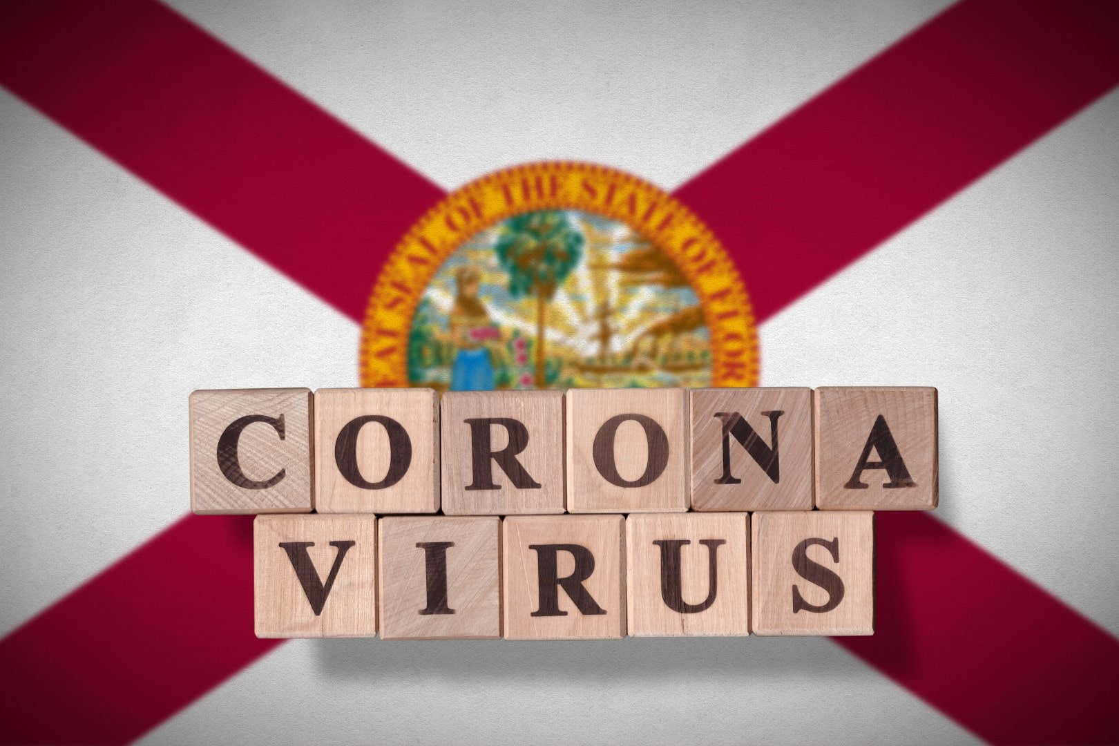 Flag of the state of Florida with wooden cubes spelling coronavirus on it. 2019 - 2020 Novel Coronavirus (2019-nCoV) concept, for an outbreak occurs in Florida, US.