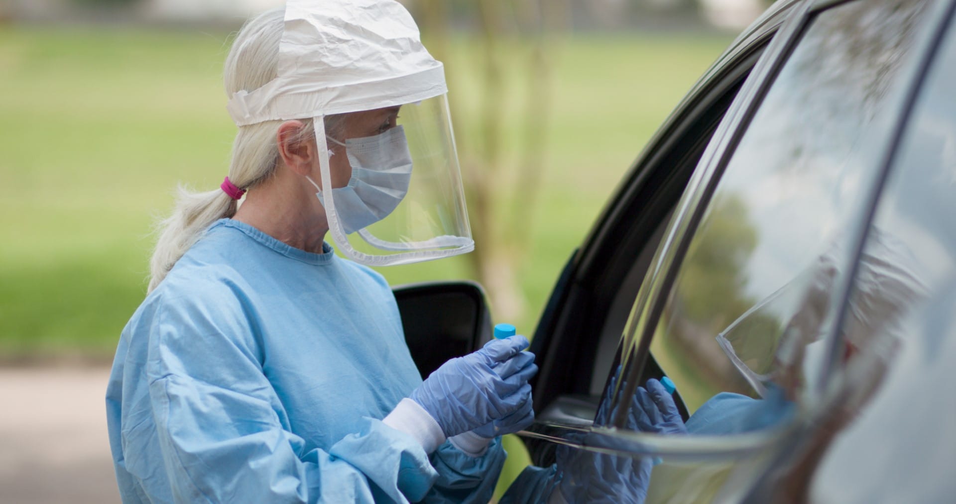 Coronavirus  or COVID19 mobile testing station healthcare worker in full protective gears finishes her task and walks toward the camera...