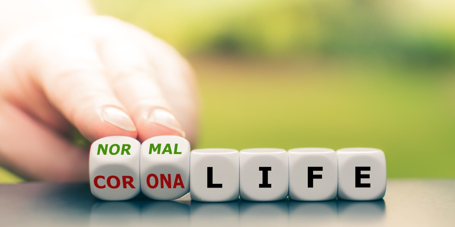 Back to normal. Hand turns dice and changes the expression "corona life" to "normal life".