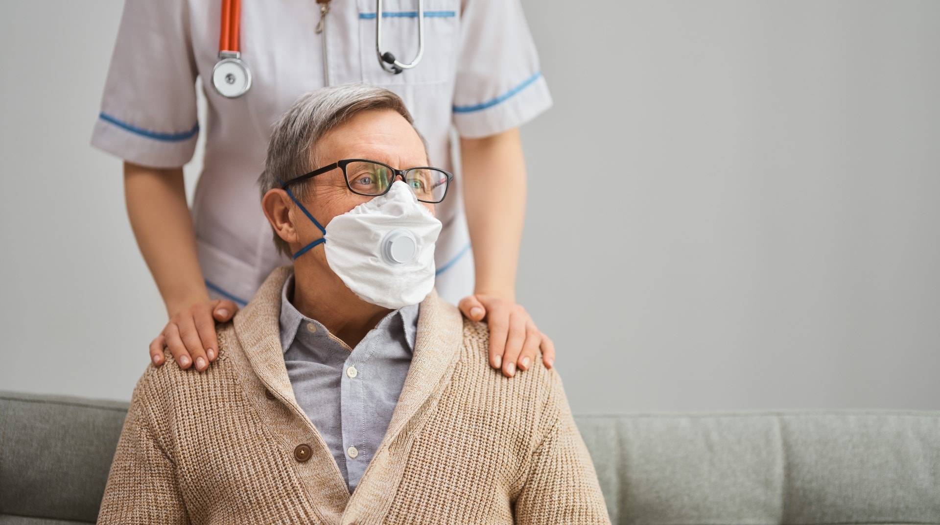 Doctor and senior man wearing facemasks nuring home long-term care facility, old man