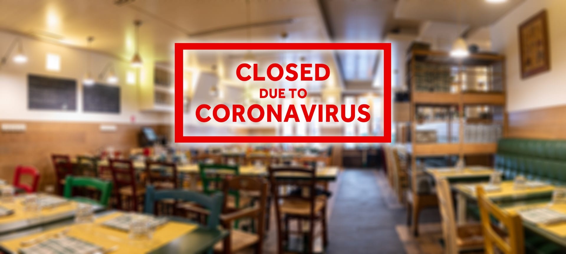 Closed due to coronavirus sign on defocused empty restaurant room