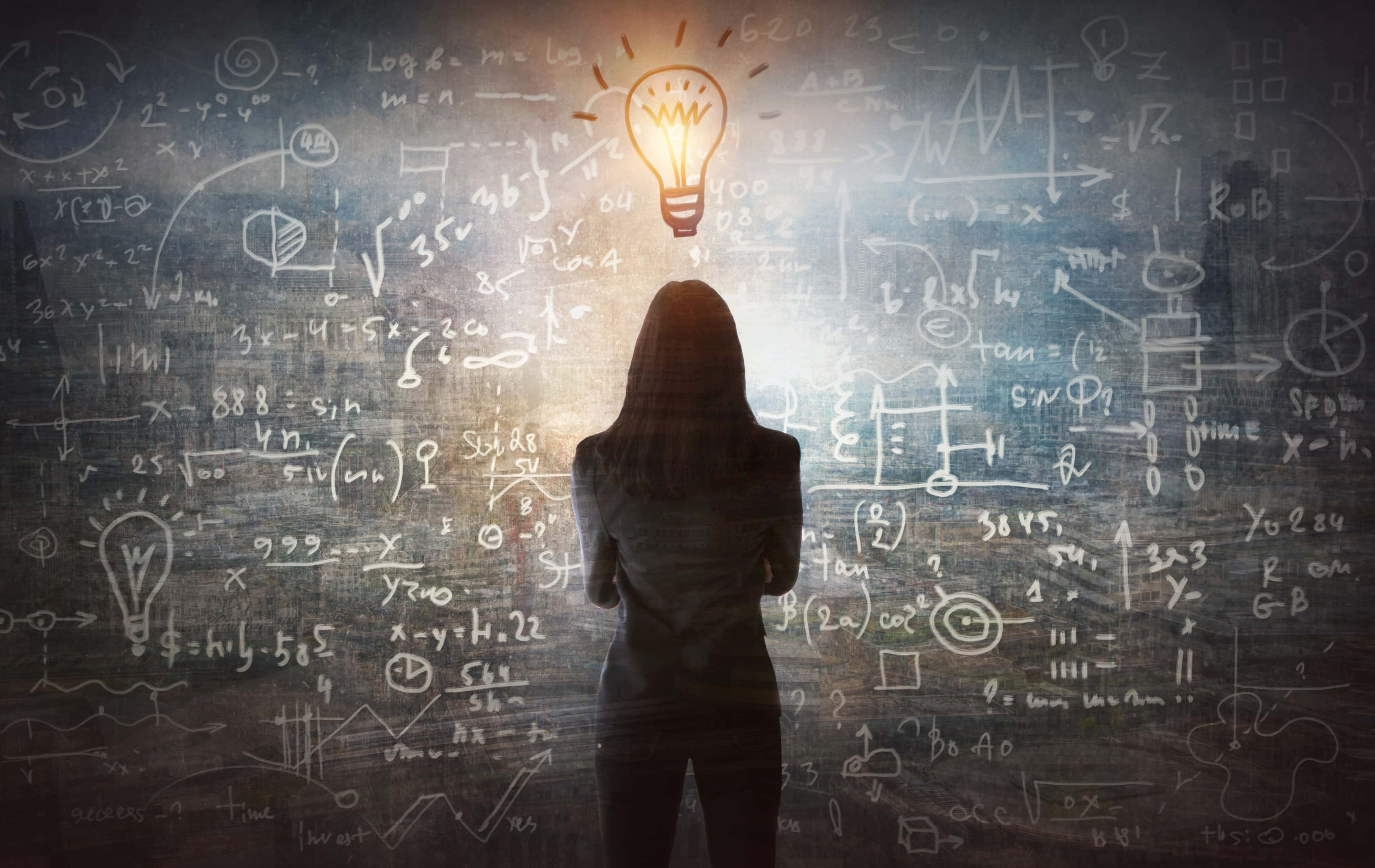 Young woman looking on the black board with mathematical formulas and calculations. Bright idea, way of thinking, discovery and challenge concept.