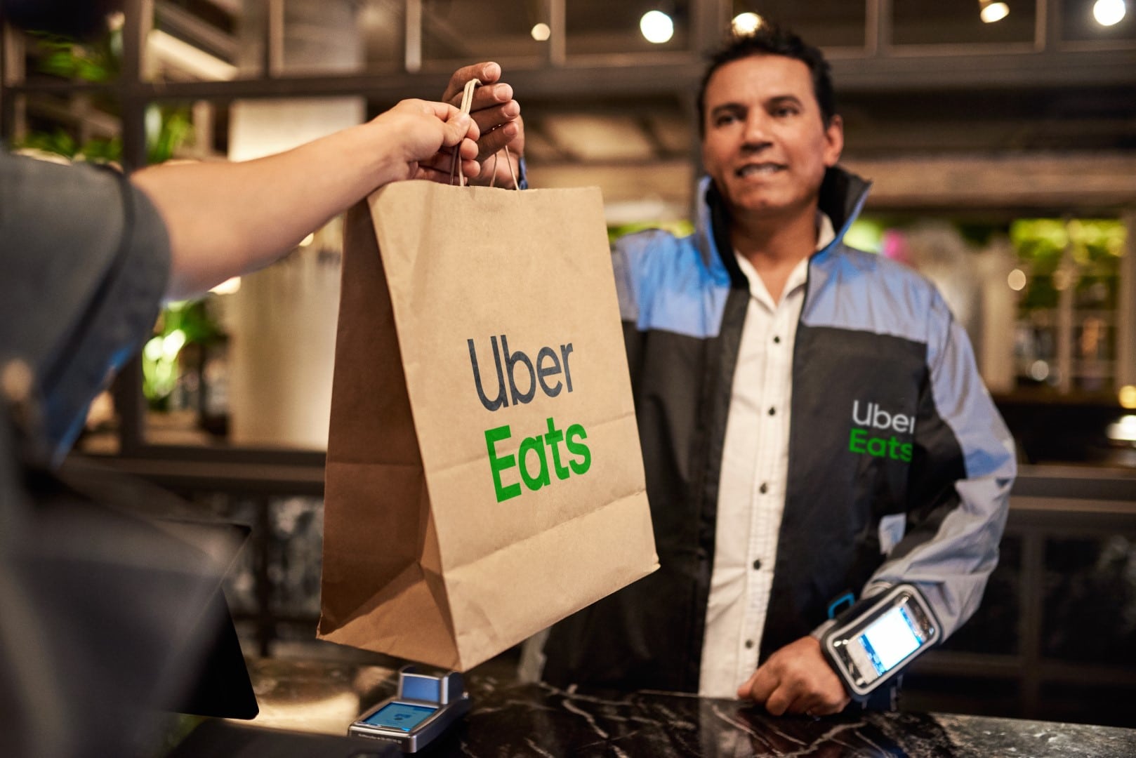 Chef giving a takeaway paper bag to a delivery man