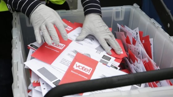 FILE - In this March 10, 2020, file photo wearing gloves, a King County Election worker collect ballots from a drop box in the Washington State primary, in Seattle. But the 2020 presidential election is creeping ever closer, and there are no signs yet of pandemic abating, nor any word on when Americans on orders to stay home can resume normal life, and so lawmakers are trying to figure how to allow for voting in a world where face-to-face contact causes anxiety at the least, and sickness and death at the most. (AP Photo/John Froschauer, File)