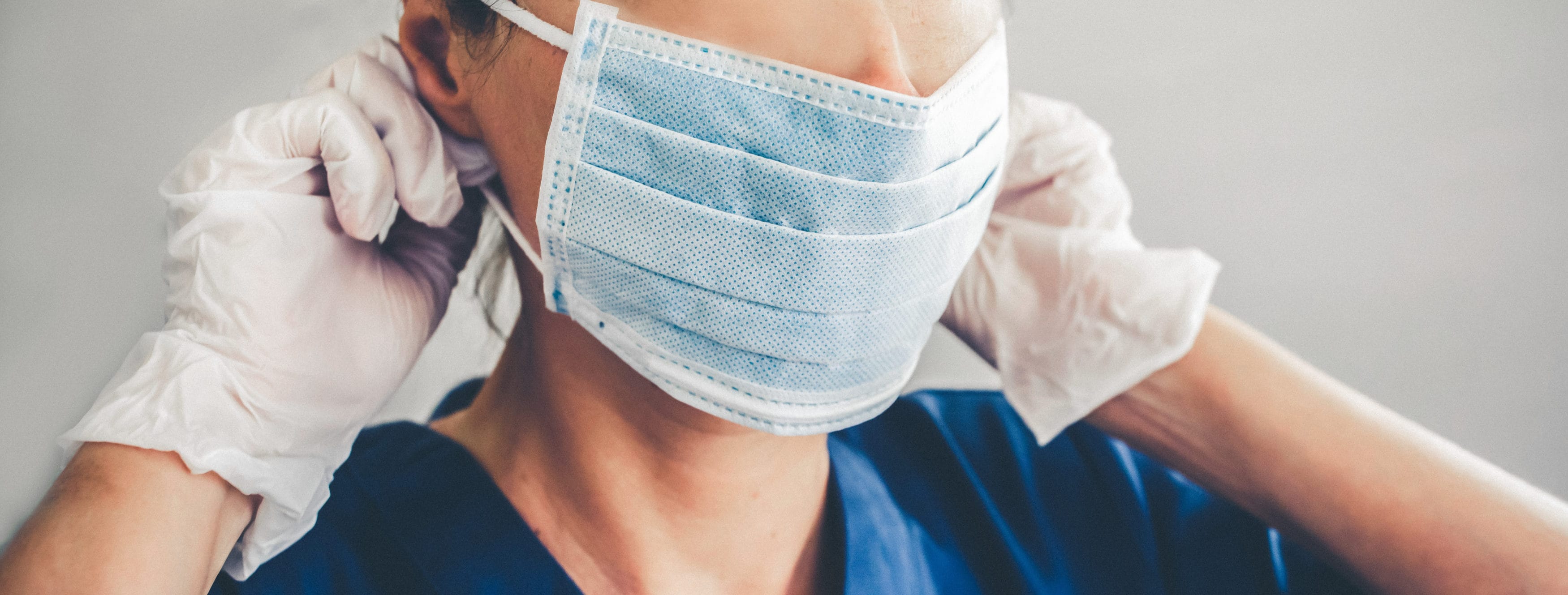 Doctor wearing protection face mask and latex gloves against coronavirus. Banner panorama medical staff preventive gear.