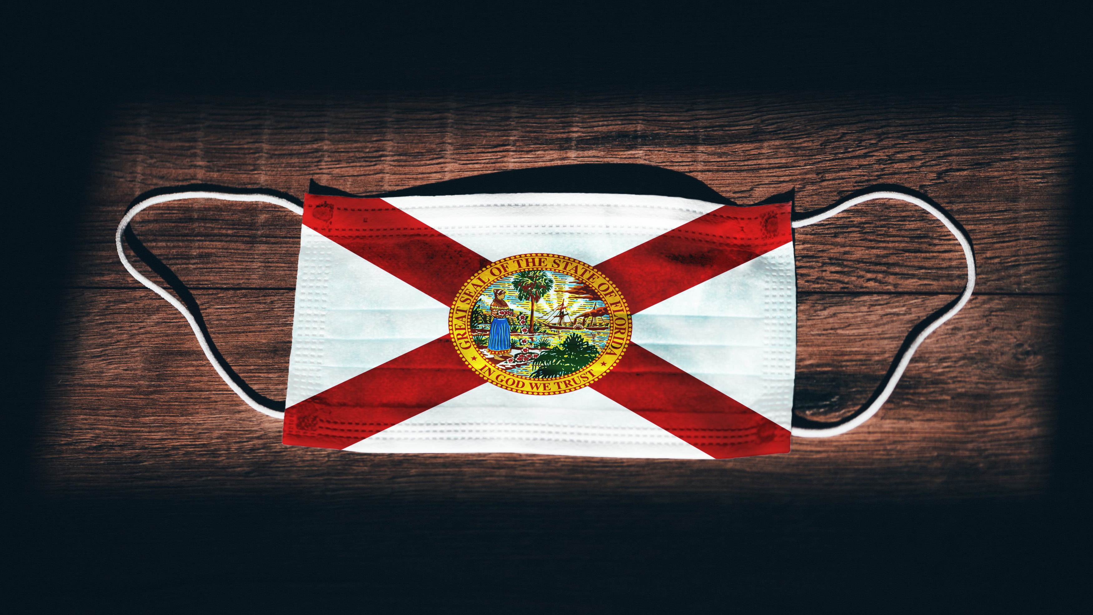 Florida Flag. Coronavirus Covid 19 in U.S. State. Medical mask isolate on a black background. Face and mouth masks for protection against airborne infections in USA, America