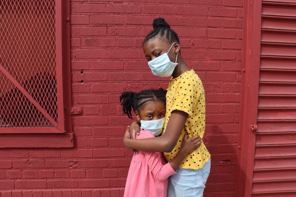 African American Girls Hugging Wearing Surgical Masks