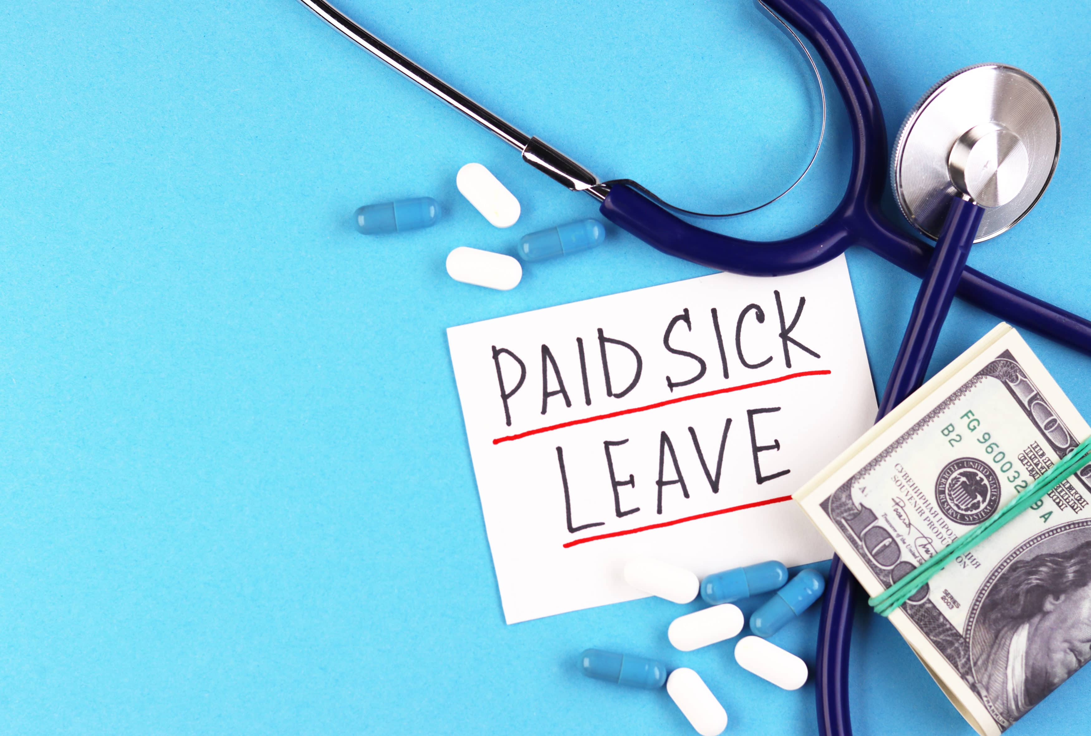 phonendoscope, money and the text paid sick leave on a blue background