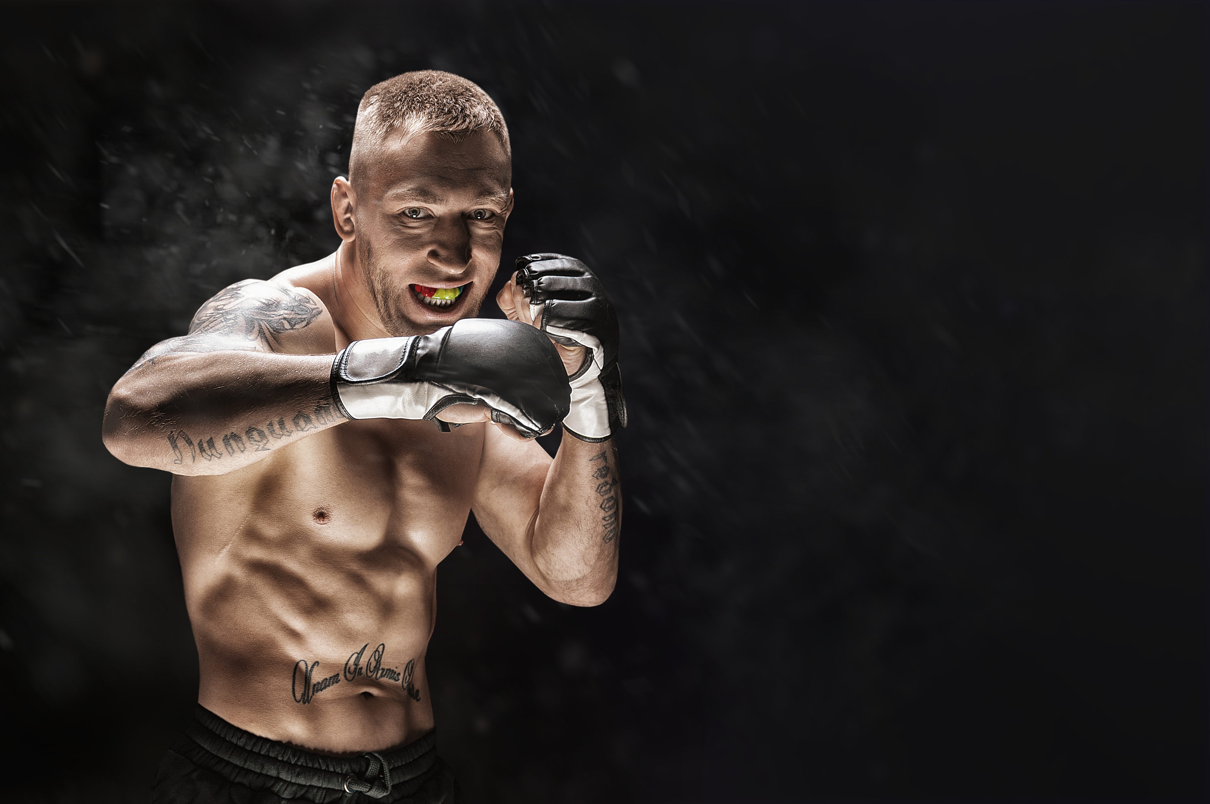 Mixed martial artist posing on a black background. Concept of mma, ufc, thai boxing, classic boxing.