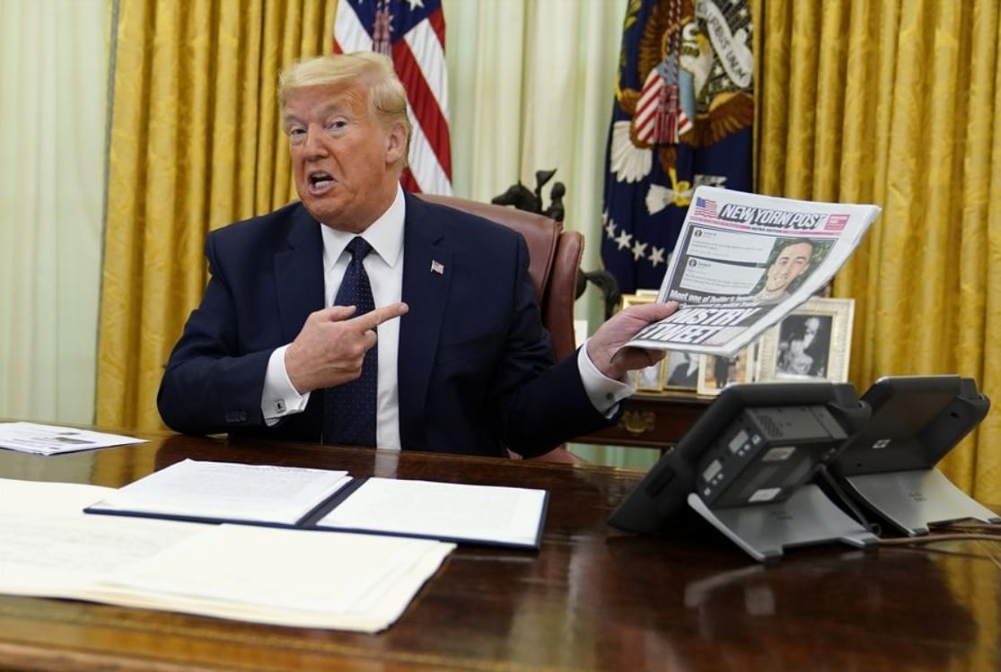 President Donald Trump holds up a copy of the New York Post as speaks before signing an executive order aimed at curbing protections for social media giants,