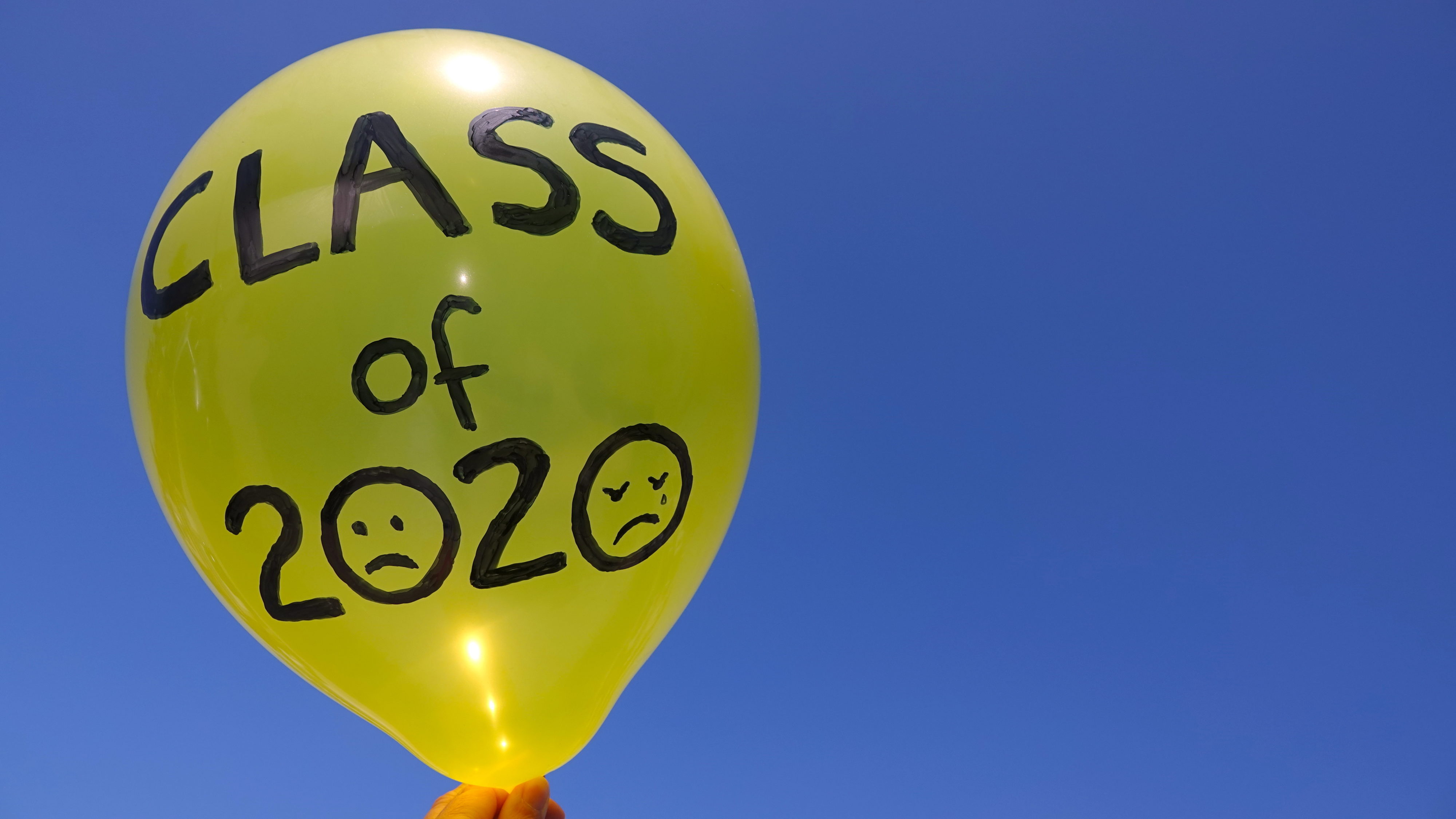 A sad "Class of 2020" balloon against a blue sky, with lots of copy space. Concept of cancelled graduation ceremonies due to Covid-19.