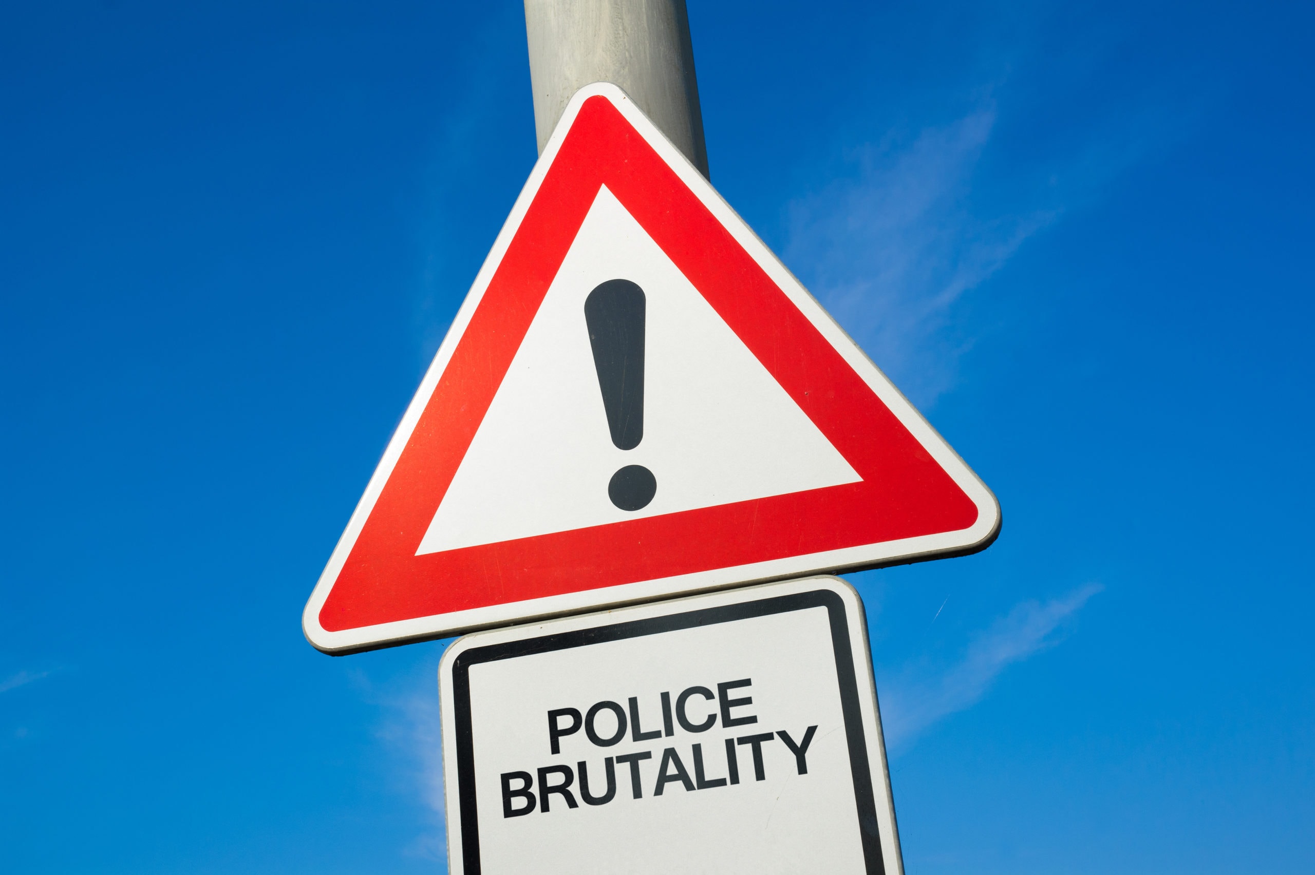 Police brutality - traffic sign with exclamation mark to alert, warn caution - precaution and warning of violent, harmful and repressive attack made by policemen and cops