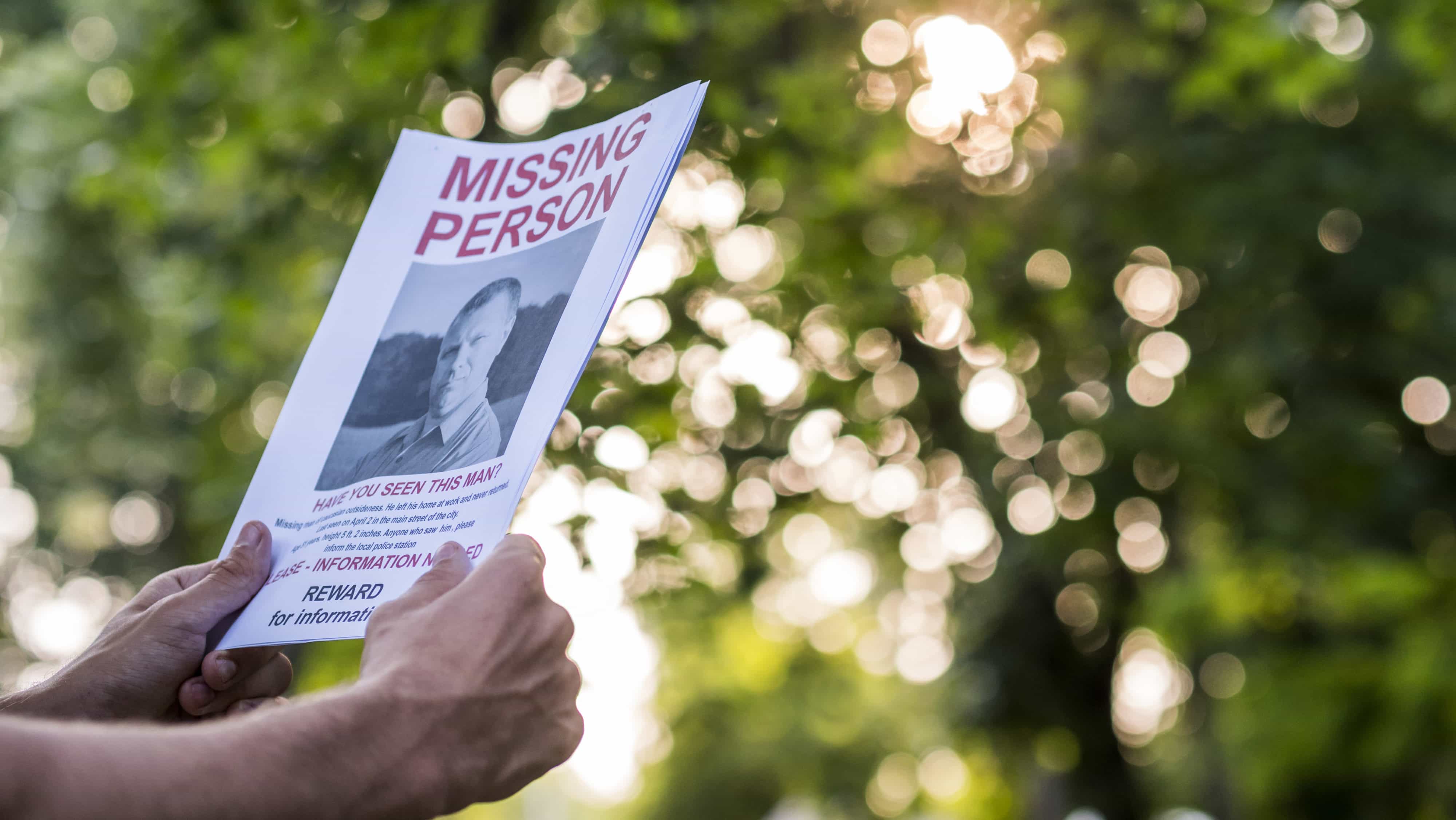 Man holding a flyer with the announcement of the missing man