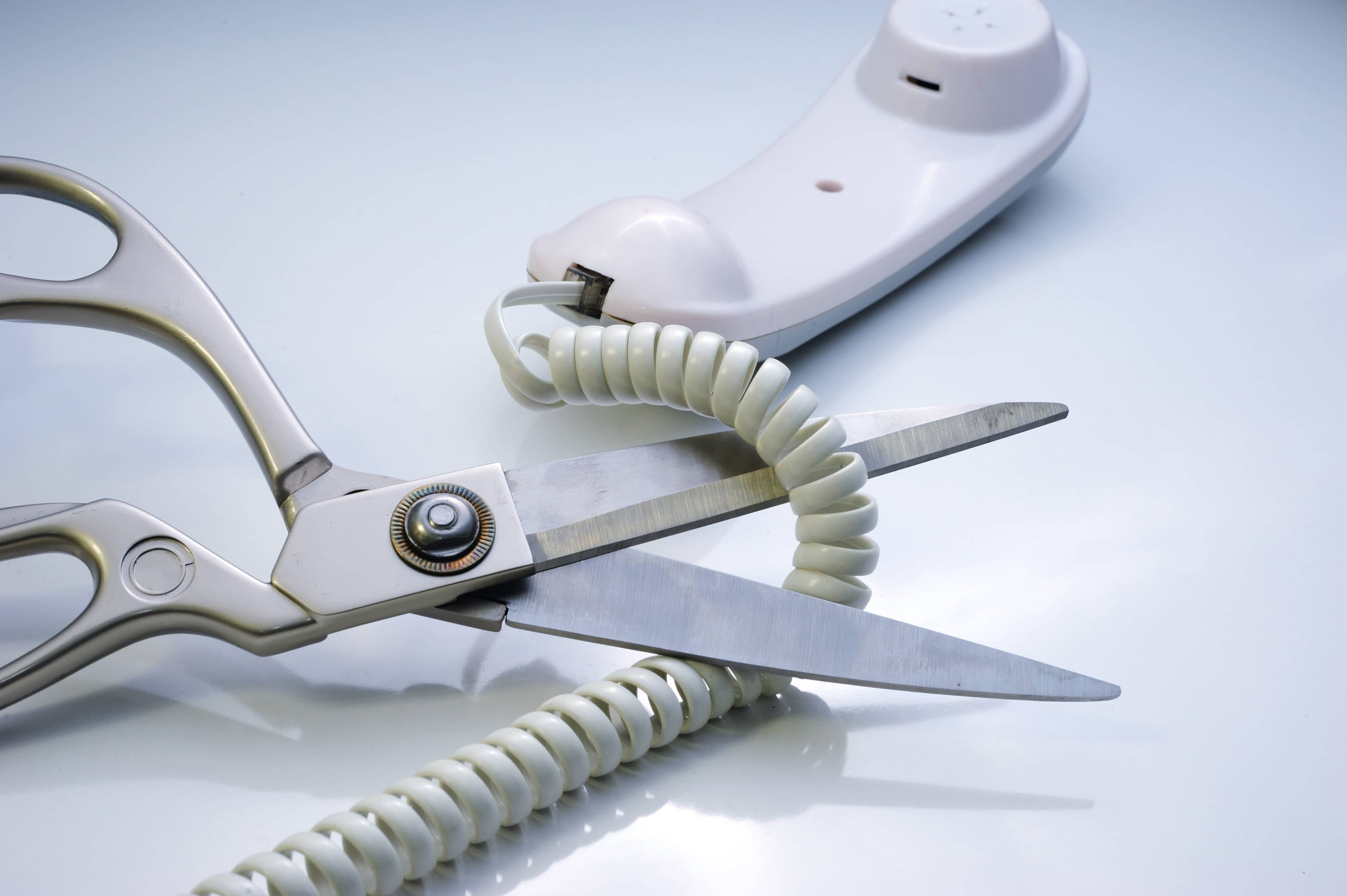 Telephone cord being cut by scissors