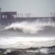 Waves crash near a pier, at Gulf State Park, Tuesday, Sept. 15, 2020, in Gulf Shores, Ala. Hurricane Sally is crawling toward the northern Gulf Coast at just 2 mph, a pace that's enabling the storm to gather huge amounts of water to eventually dump on land. (AP Photo/Gerald Herbrt)