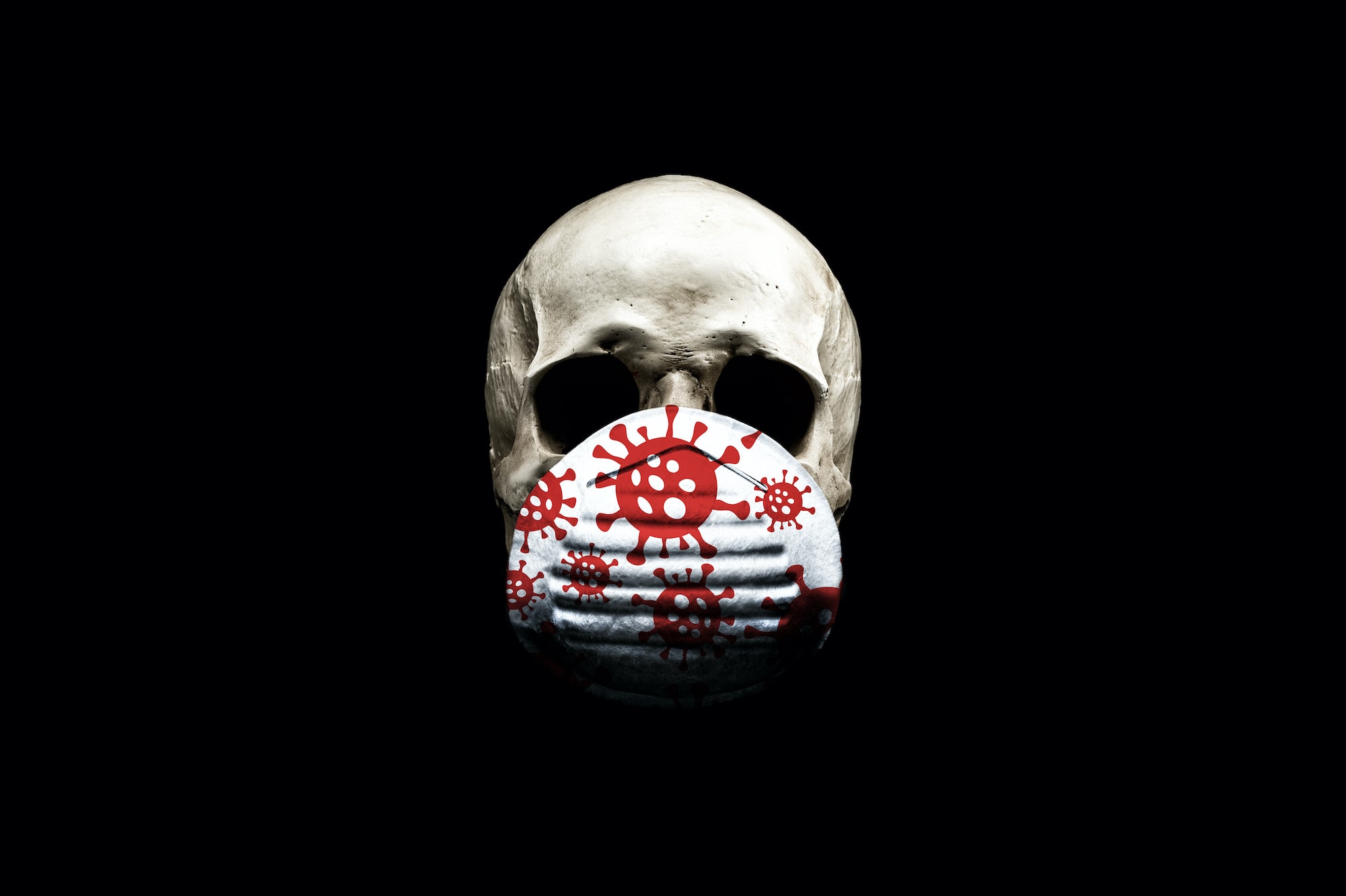 Skull in a medical mask isolated on black background . The concept of an epidemic. Coronavirus protection equipment.