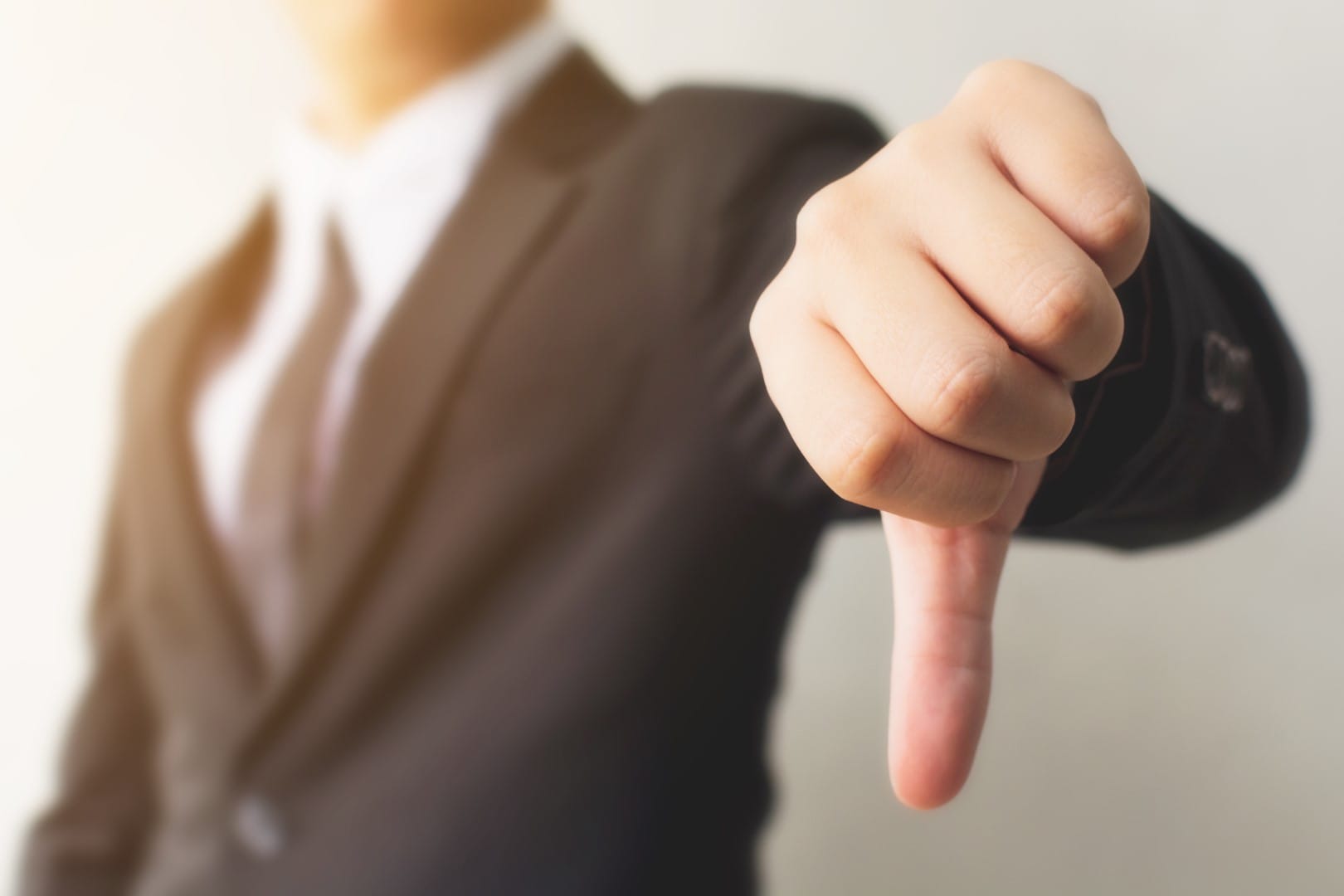 Businessman hand showing thumb down sign gesture. Dislike or bad concept