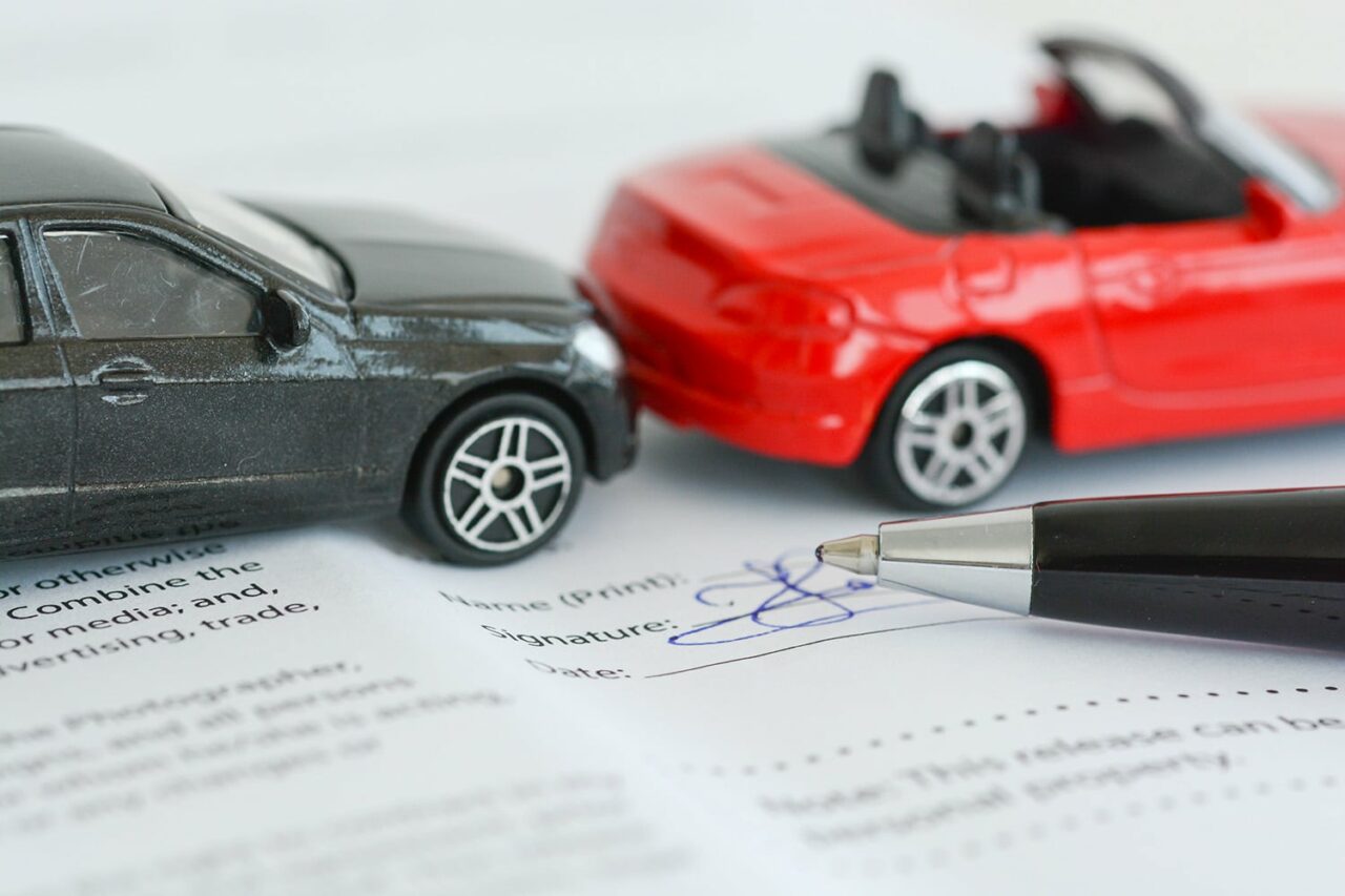 Insurance policy contract concept with toy model cars having a crash. Auto insurance, car insurance, PIP, no-fault.