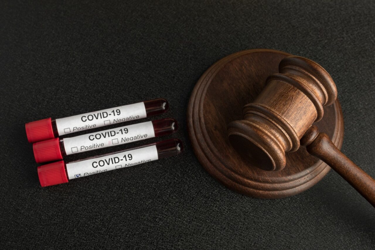 Infected blood samples in tubes COVID 19 and judge's gavel. Punishment for the spread of infection