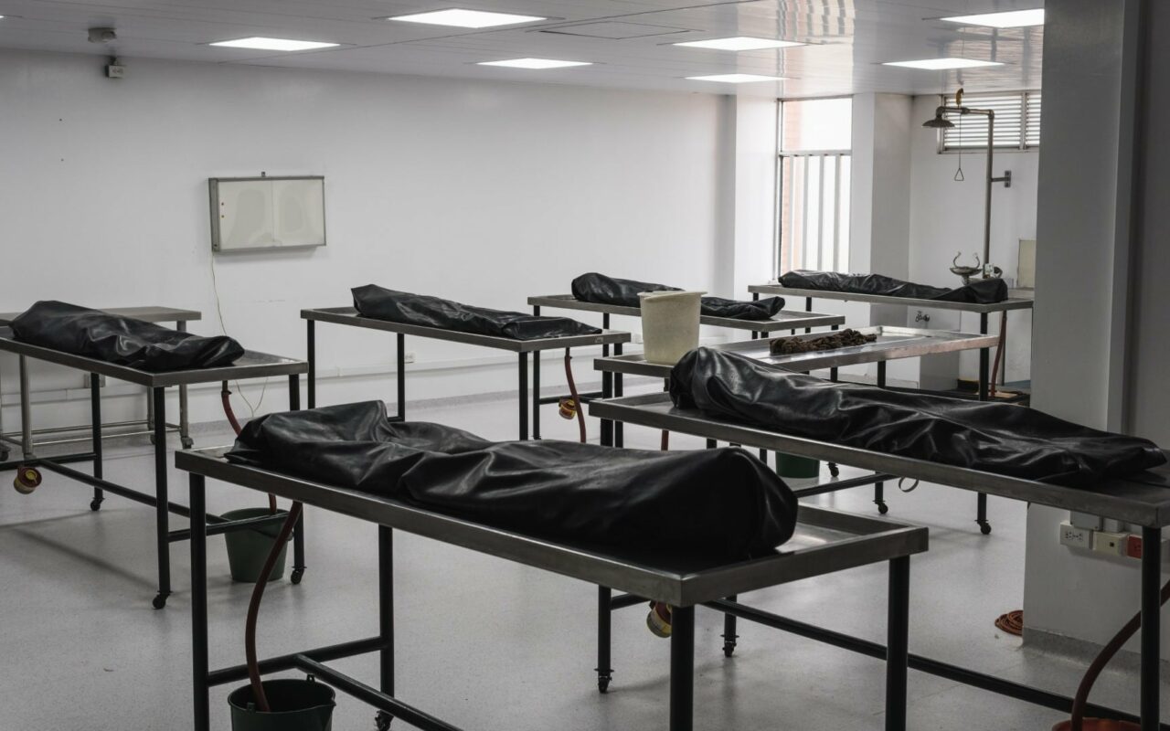 Covered human corpses on tables in a morgue / mortuary waiting for identification, autopsy, burial or cremation. Taken in Armenia, Colombia.