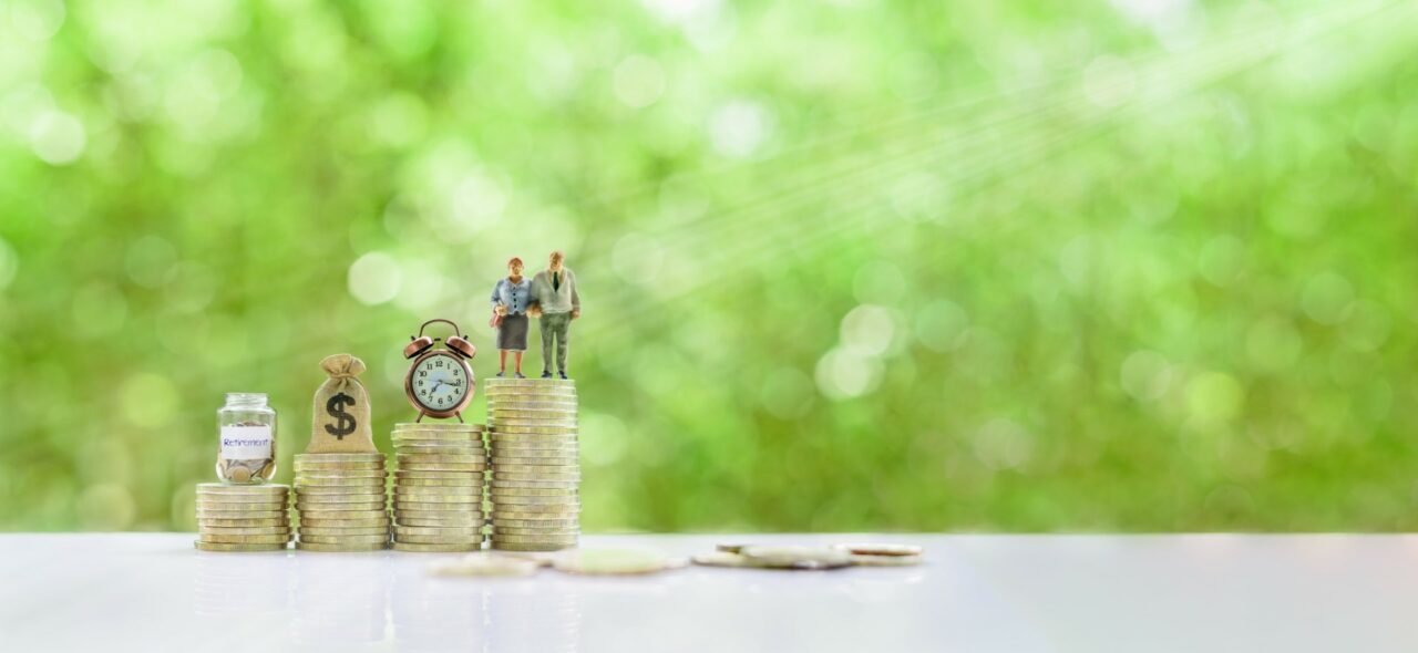 Saving for retirement and pension fund concept : Senior retired couple, vintage clock, US dollar money bag, deposit saving jar on steps of rising coins, depicts long-term investment for aging society