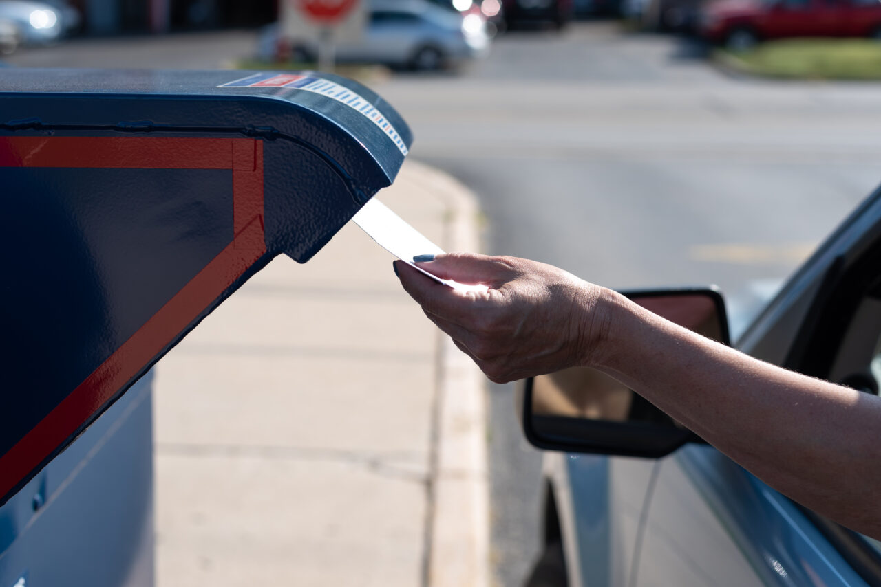 Palatine, IL/USA - 08-27-2020:  A woman is safely and contactlessly mailing in her application for ballot for 2020 election at the Post Office