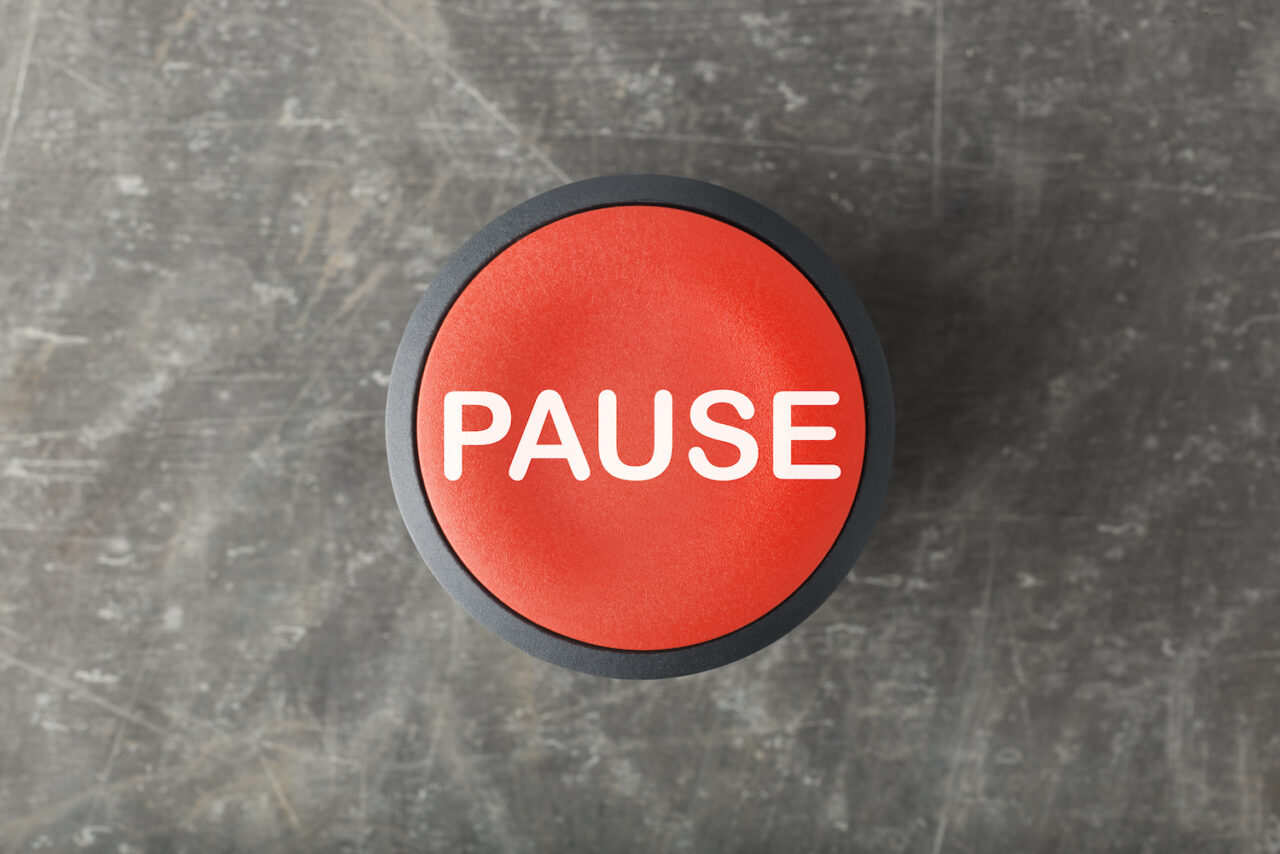 Overhead of Red Pause Push Button on Concrete Background