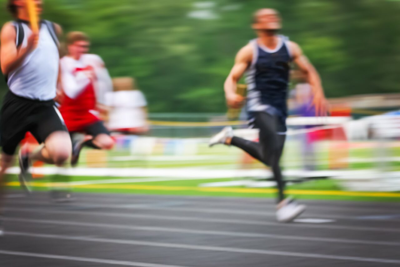 Motion blurred men in a track and field relay race