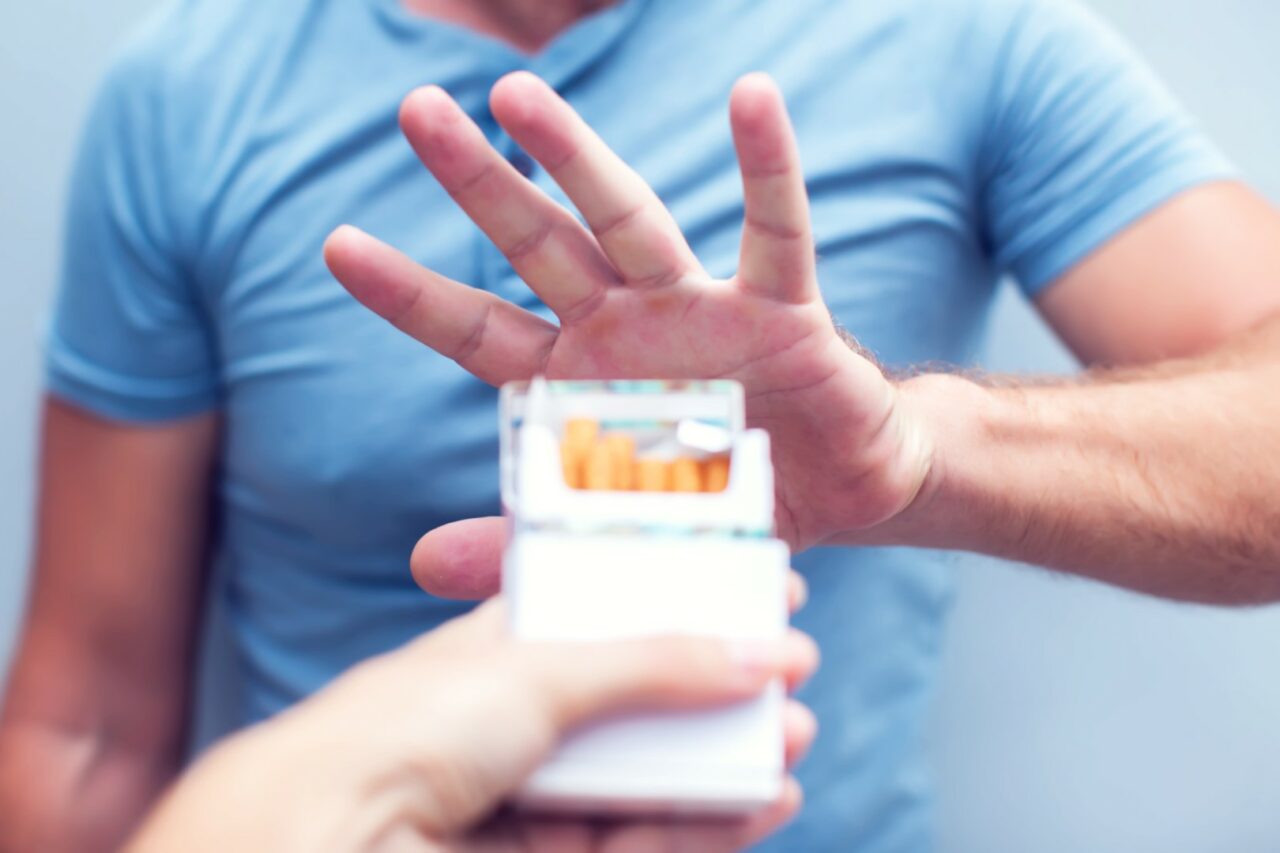 Man refusing a cigarette from a pack of smokes concept for quitting smoking and healthy lifestyle