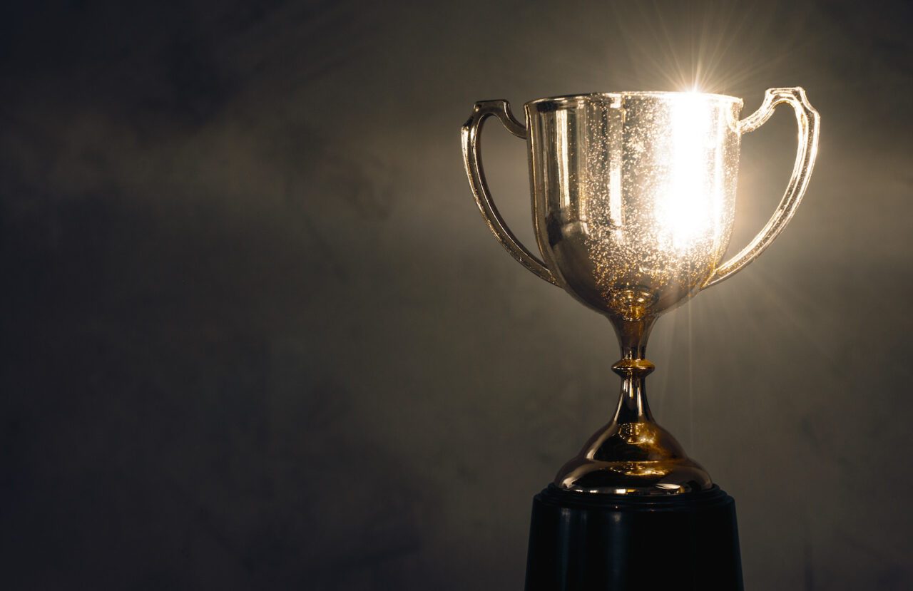 champion golden trophy placed on wooden table