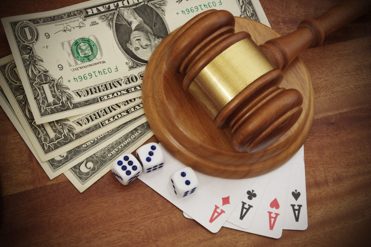 Gambling and law concept, playing cards, money, dices and wooden judge gavel