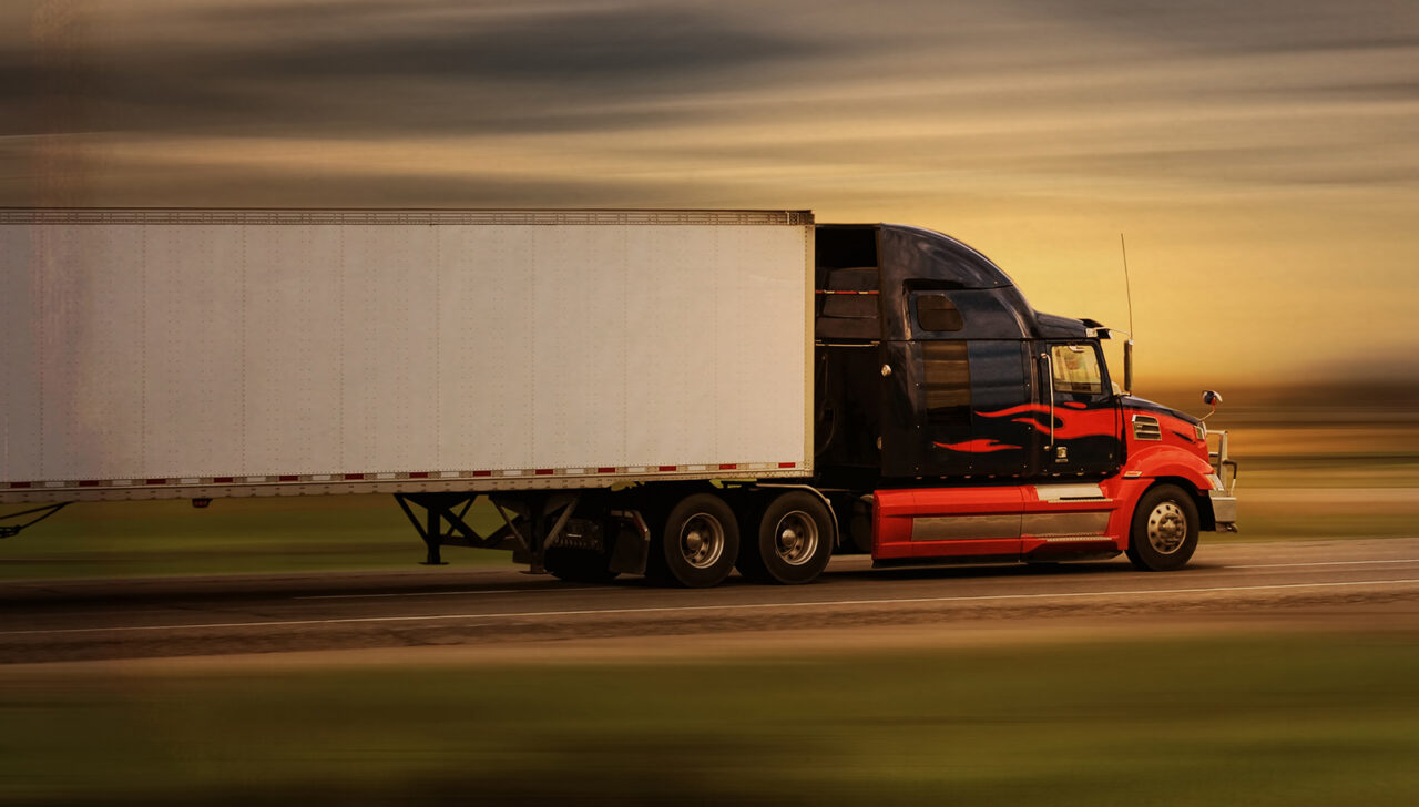 Bright modern big rig semi truck and trailer in motion on a high