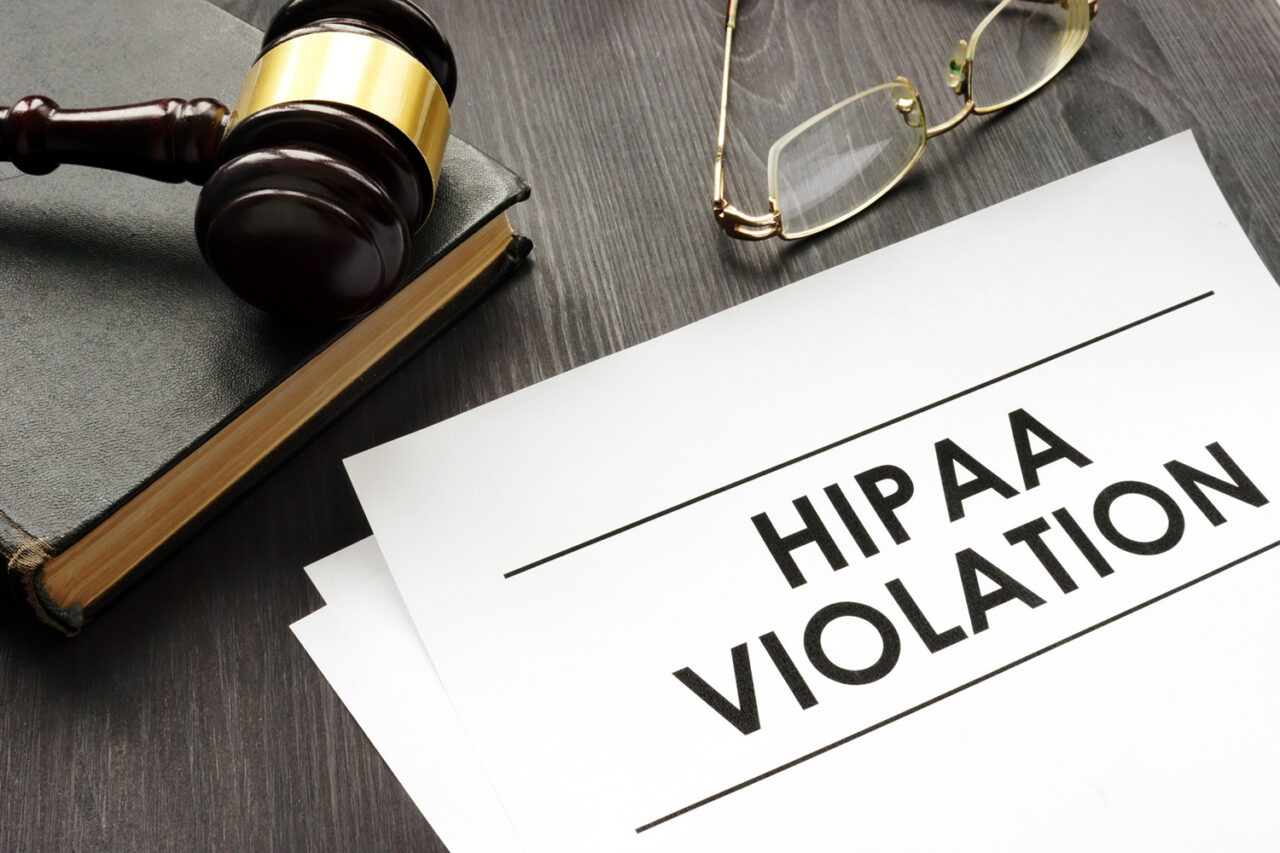 Documents about HIPAA violation and gavel in a court.