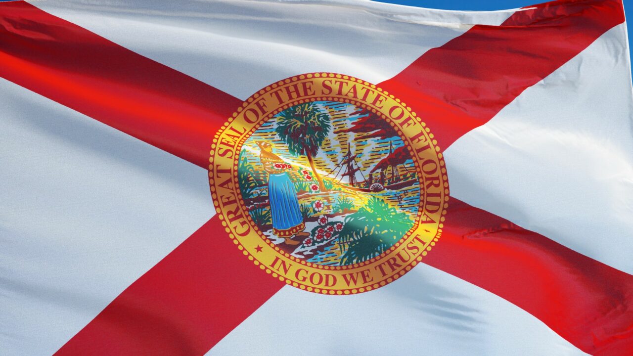 Florida (U.S. state) flag waving against clear blue sky, close up, isolated with clipping path mask alpha channel transparency, perfect for film, news, composition