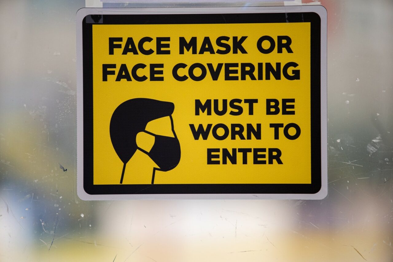A signpost enforces the CDC's face mask mandate.