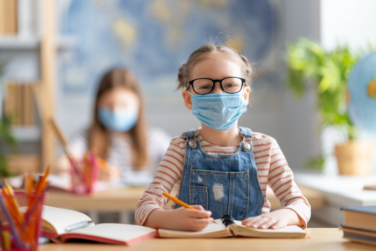 Kids are wearing facemasks learning in class