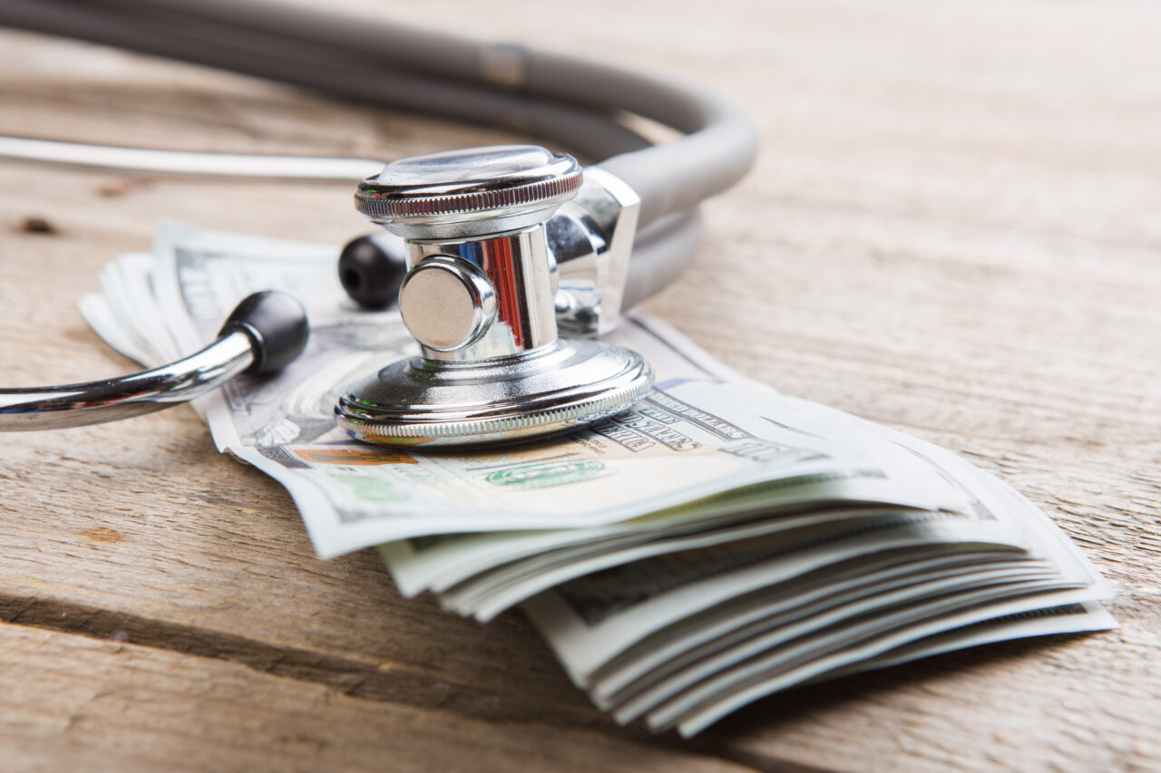 health insurance concept - stethoscope over the money