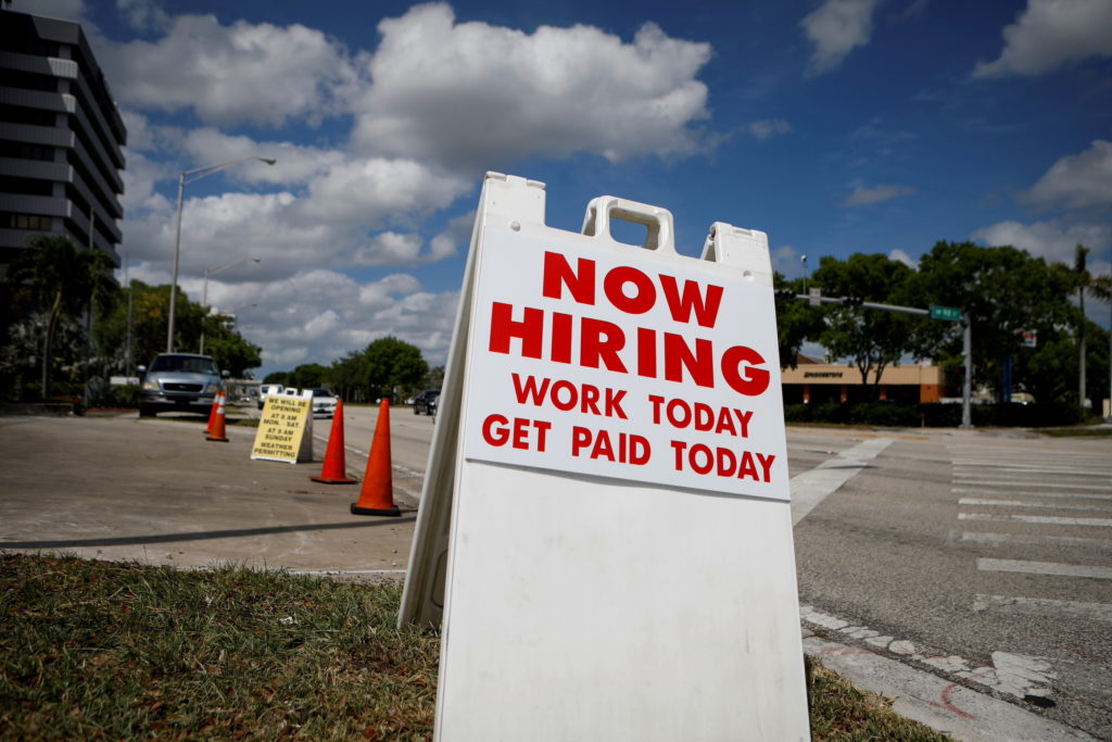 FILE PHOTO: A "Now Hiring" sign advertising jobs at a hand car wash is seen in Miami