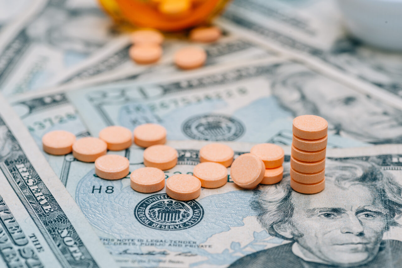 money and pills in pill bottle and stethoscope on table medical expense concept